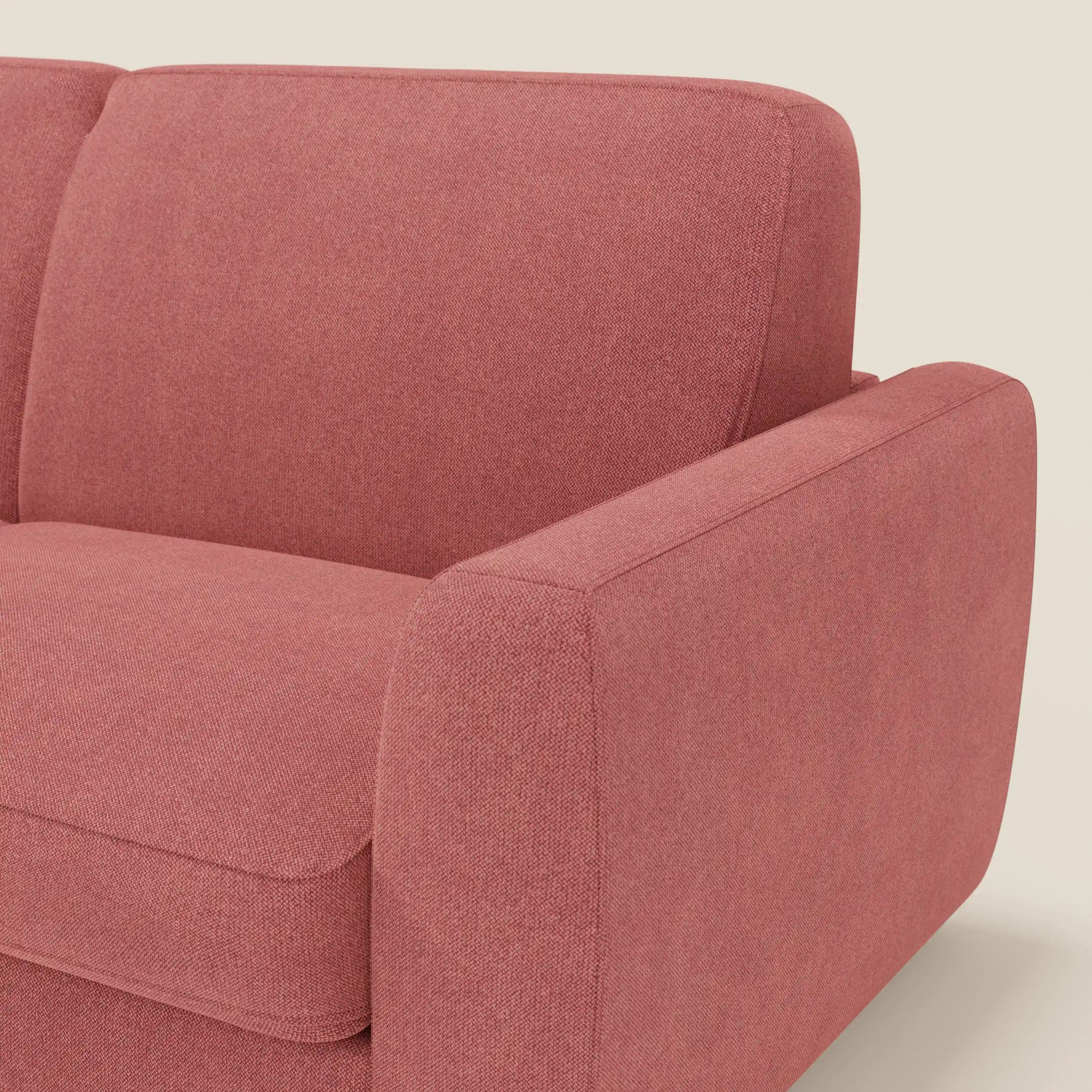 Un primo piano del divano letto sfoderabile Leonida di Divani.Store, rivestito in tessuto Smacchiabile T23 rosso ciliegia. L'immagine mostra il bracciolo, la seduta e il cuscino dello schienale dalle linee pulite e il meccanismo in acciaio rinforzato.