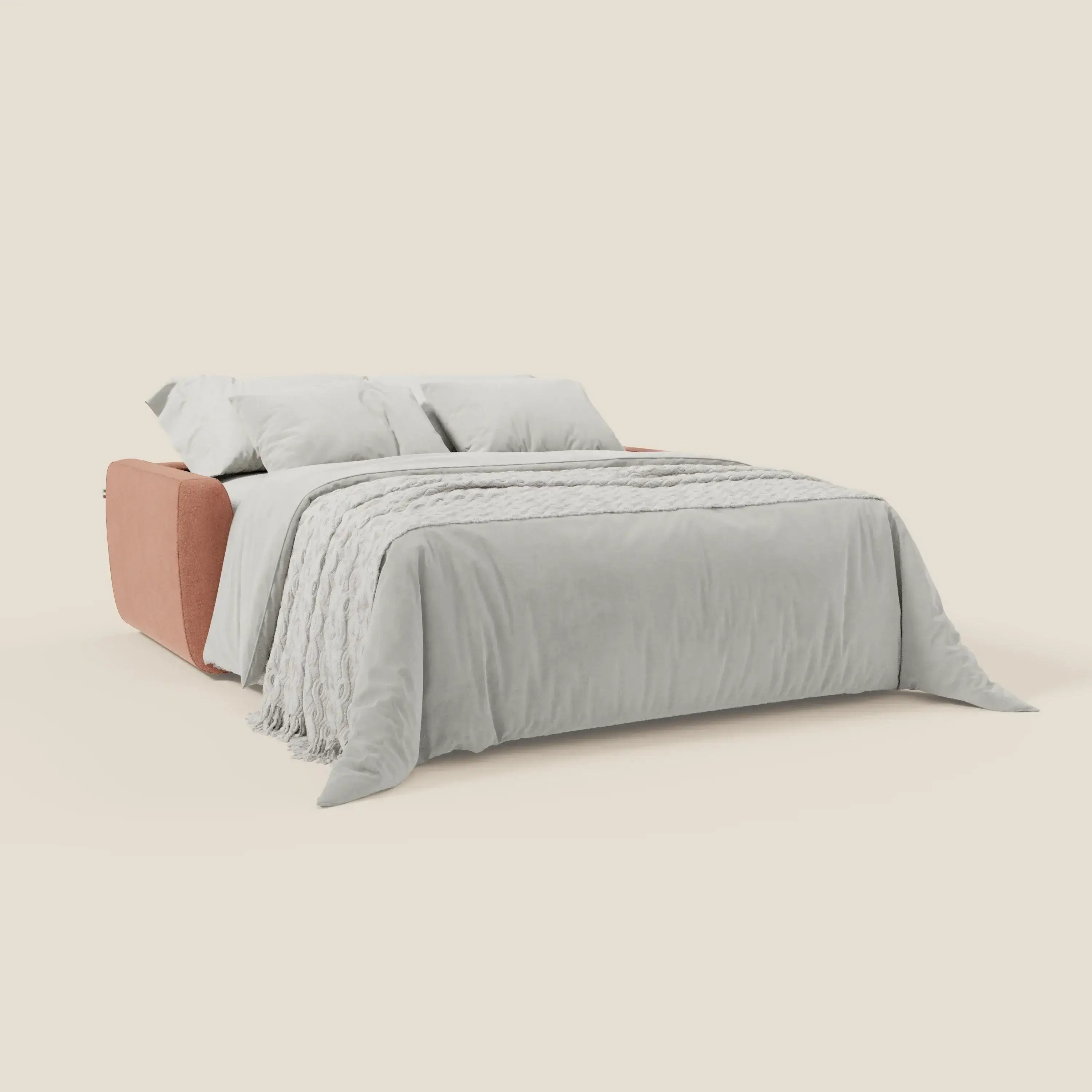 Il divano letto Leonida di Divani.Store è sfoderabile in tessuto antimacchia T23 pesca, materasso H18 cm, cuscini coordinati, copriletto bianco testurizzato, ampi braccioli imbottiti in terracotta tenue e meccanismo in acciaio rinforzato.