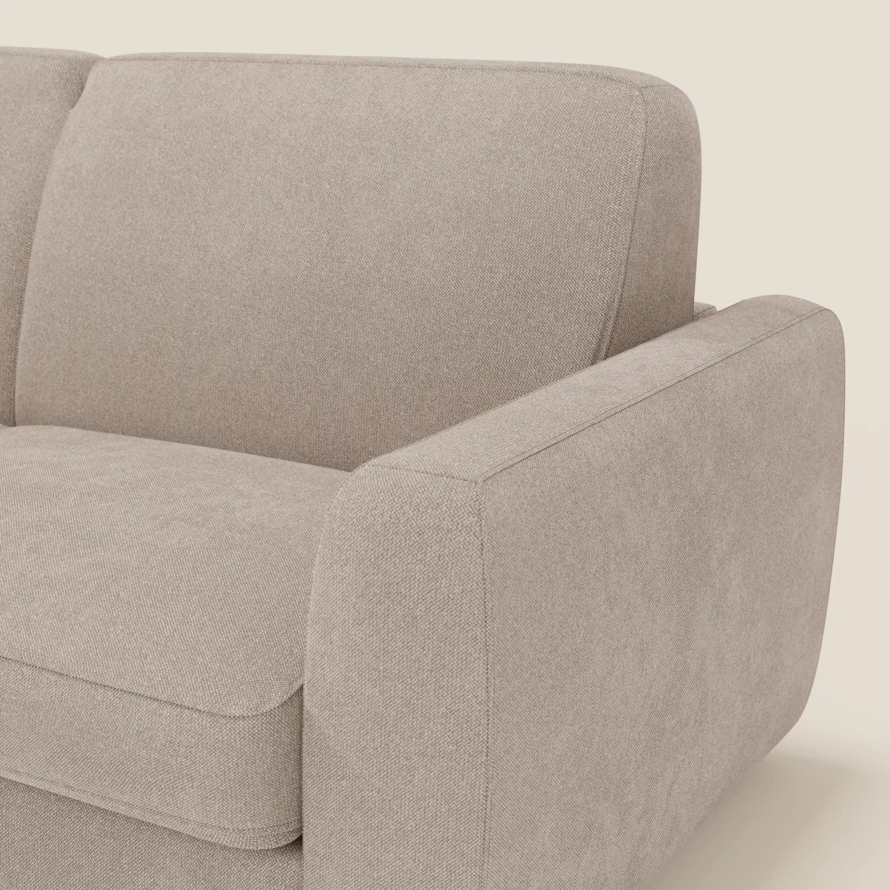 Primo piano del divano letto sfoderabile Leonida di Divani.Store in tessuto Smacchiabile T23 tortora, con bracciolo destro, seduta, cuscino di schienale e materasso H18 cm. Linee pulite e design minimalista su sfondo chiaro.