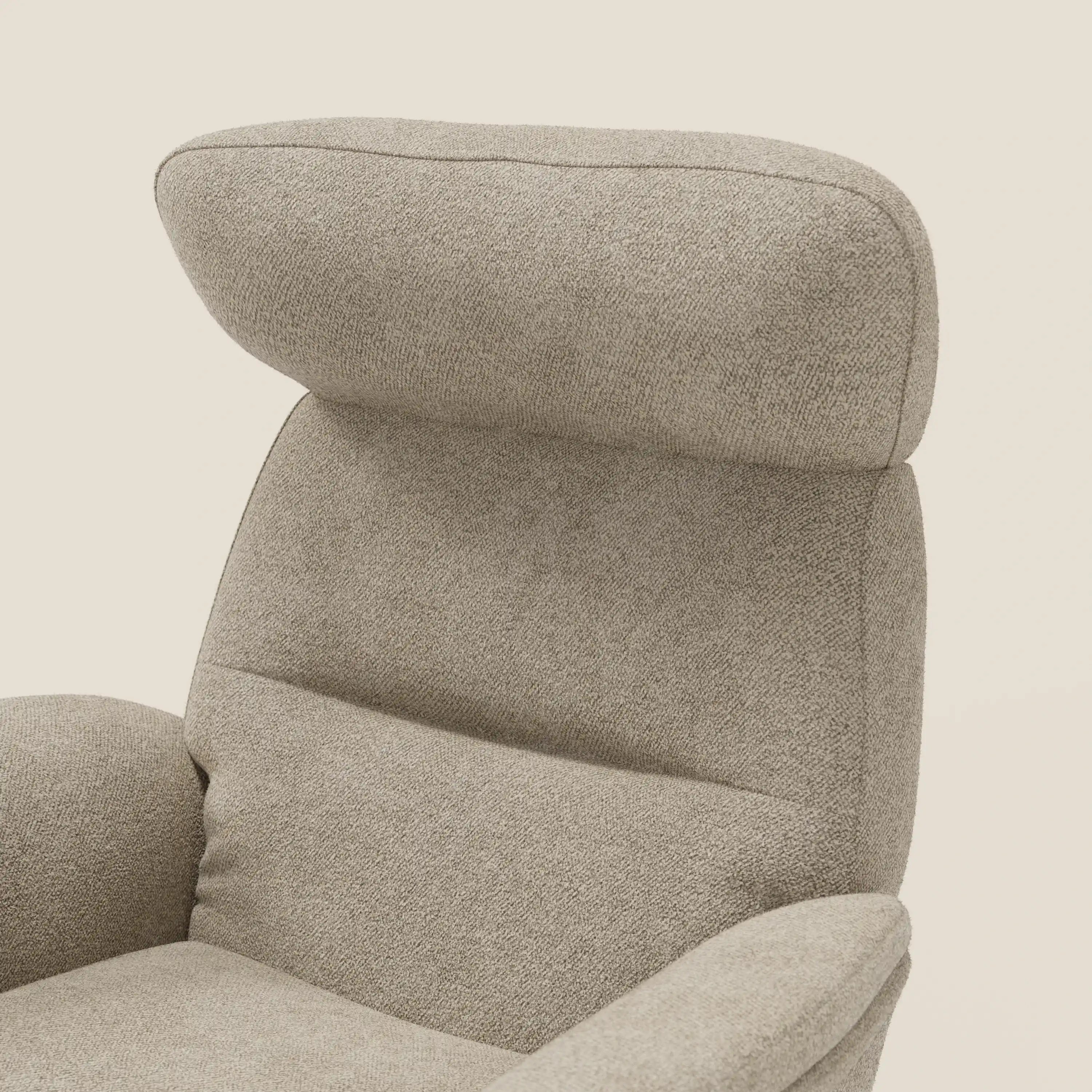 Primo piano della poltrona relax Lunor reclinabile con pouf poggiapiedi di Divani.Store, caratterizzata da uno schienale alto e imbottito e da un poggiatesta rivestito in tessuto bouclé impermeabile T07 beige con braccioli lisci e curvi su sfondo chiaro.