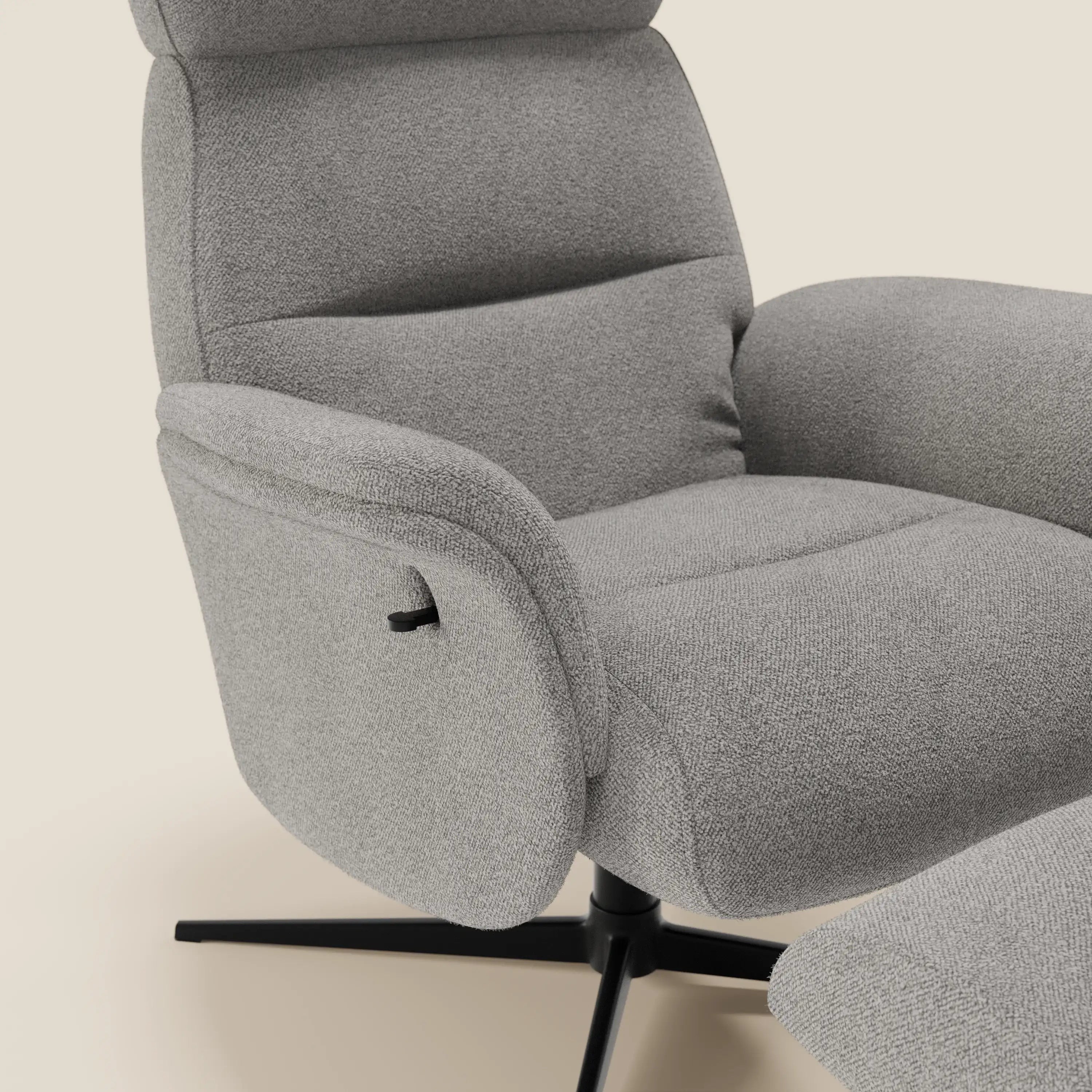 Primo piano della poltrona relax reclinabile Lunor di Divani.Store in bouclé impermeabile grigio chiaro T07, con schienale alto, ampia seduta imbottita, braccioli imbottiti, base girevole in metallo nero e pouf coordinato su sfondo beige.