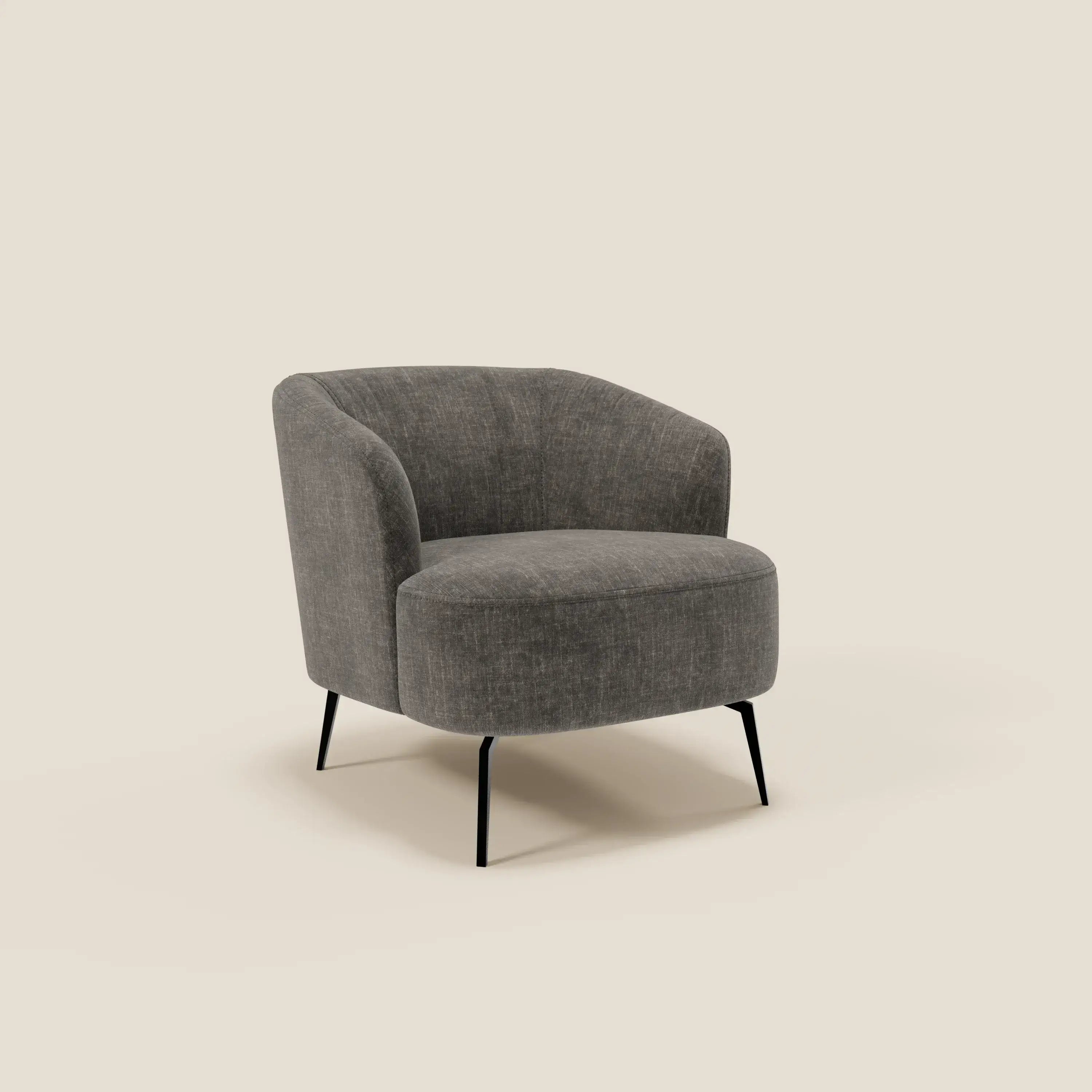 La Renoa Poltroncina dall'eleganza moderna di Divani.Store, in tessuto smacchiabile T24 antracite, presenta schienale e seduta curvi su quattro sottili gambe nere, risaltando su sfondo beige il suo design semplice ed elegante.