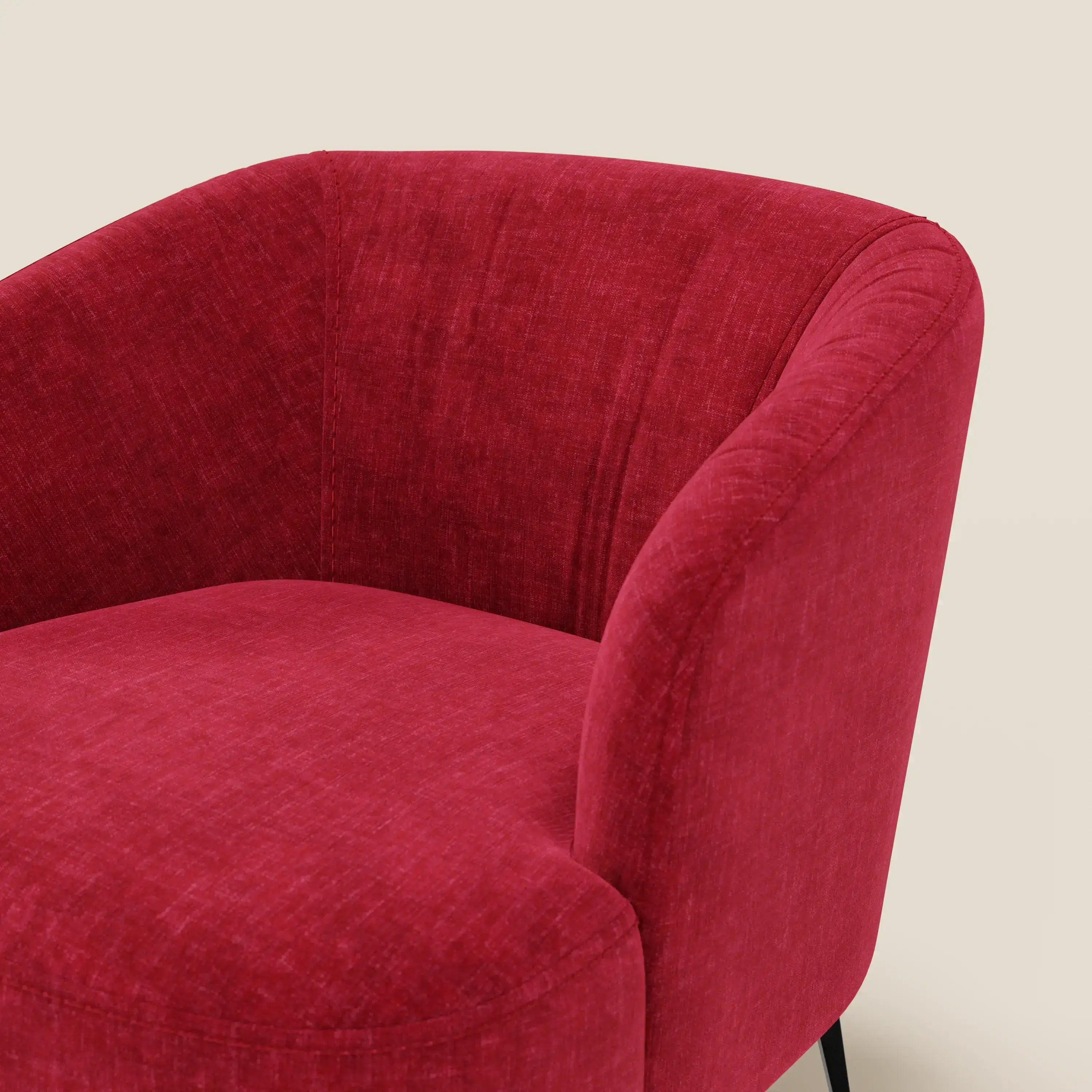 La poltroncina Renoa dall'eleganza moderna in tessuto smacchiabile T24 rosso bordeaux di Divani.Store, con braccioli curvi e schienale arrotondato, è mostrata parzialmente contro uno sfondo beige, evidenziando la texture del suo rivestimento vivace.