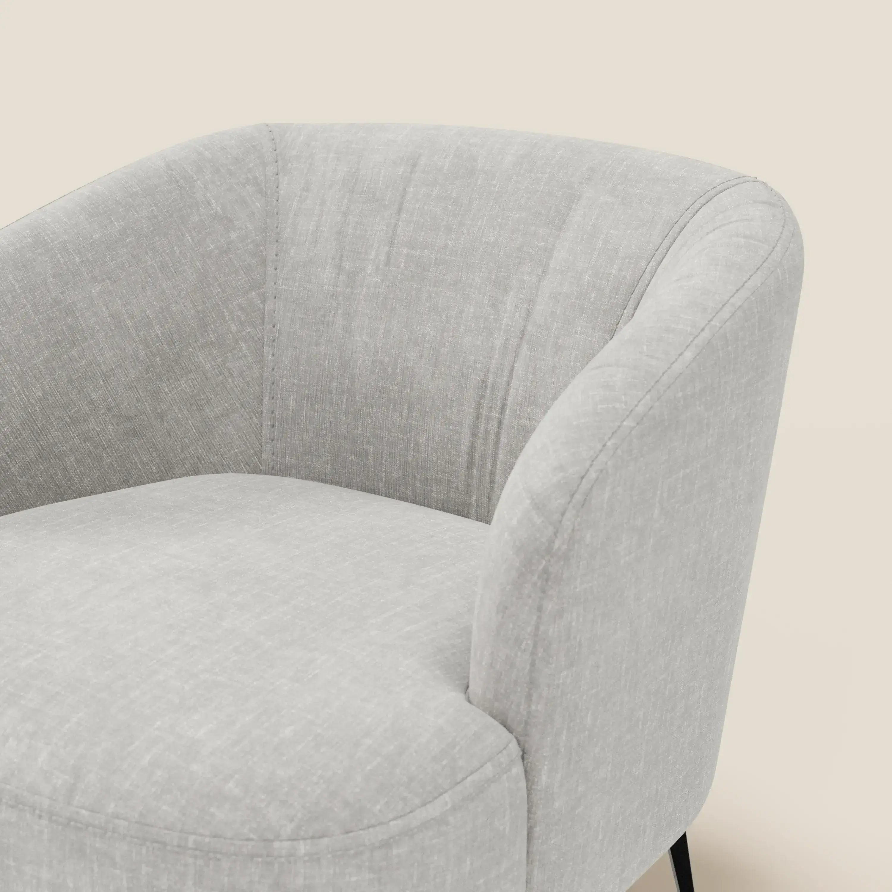 La poltroncina Renoa di Divani.Store, in tessuto smacchiabile T24 grigio chiaro, presenta un moderno schienale curvo e sottili gambe in metallo nero. Su uno sfondo beige, sono visibili solo la parte superiore e quella sinistra.