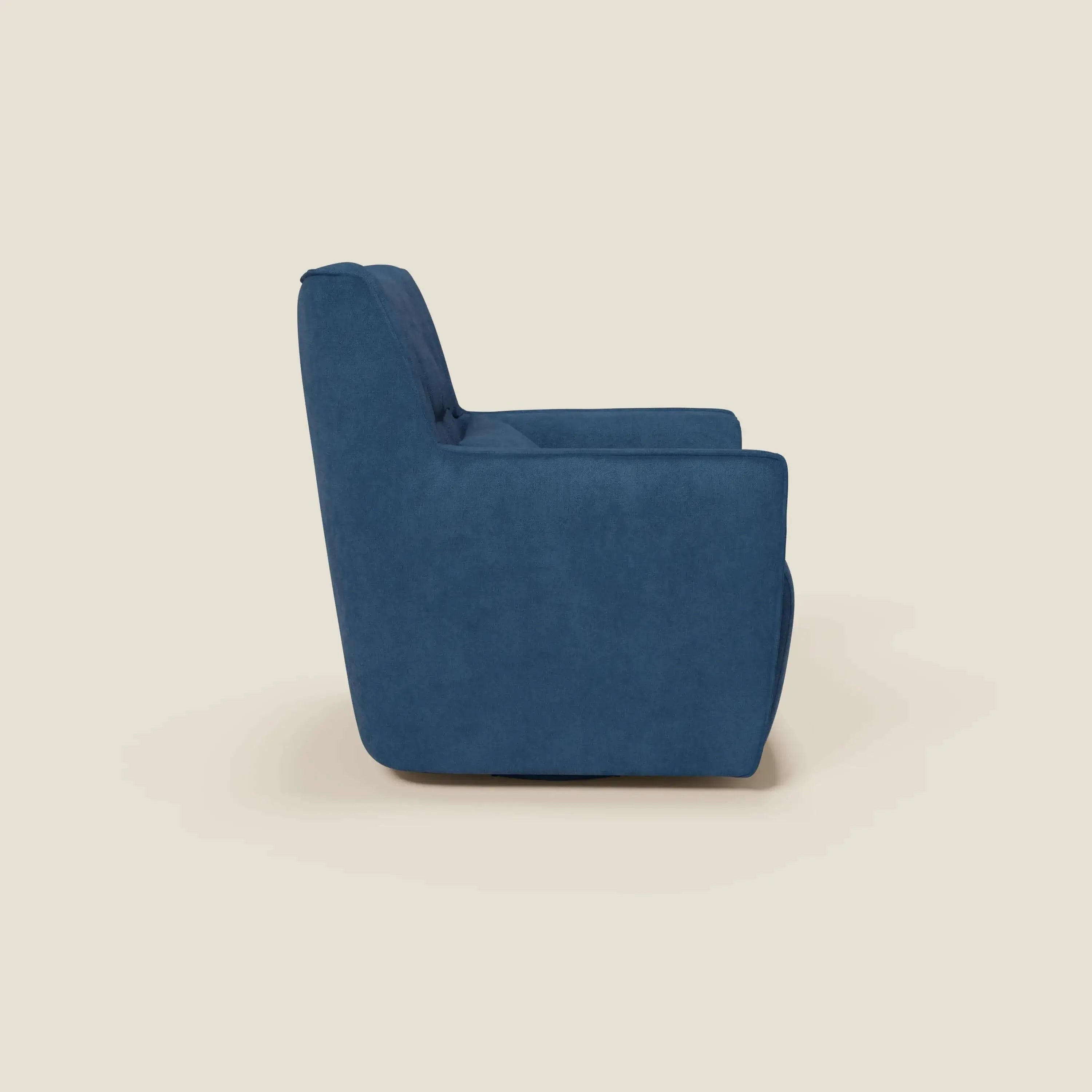 Tulla Poltrona girevole in tessuto impermeabile T02 blu di Divani.Store è presentata lateralmente su sfondo beige chiaro, con schienale alto, seduta ampia, braccioli dritti e forma squadrata con gambe a scomparsa.