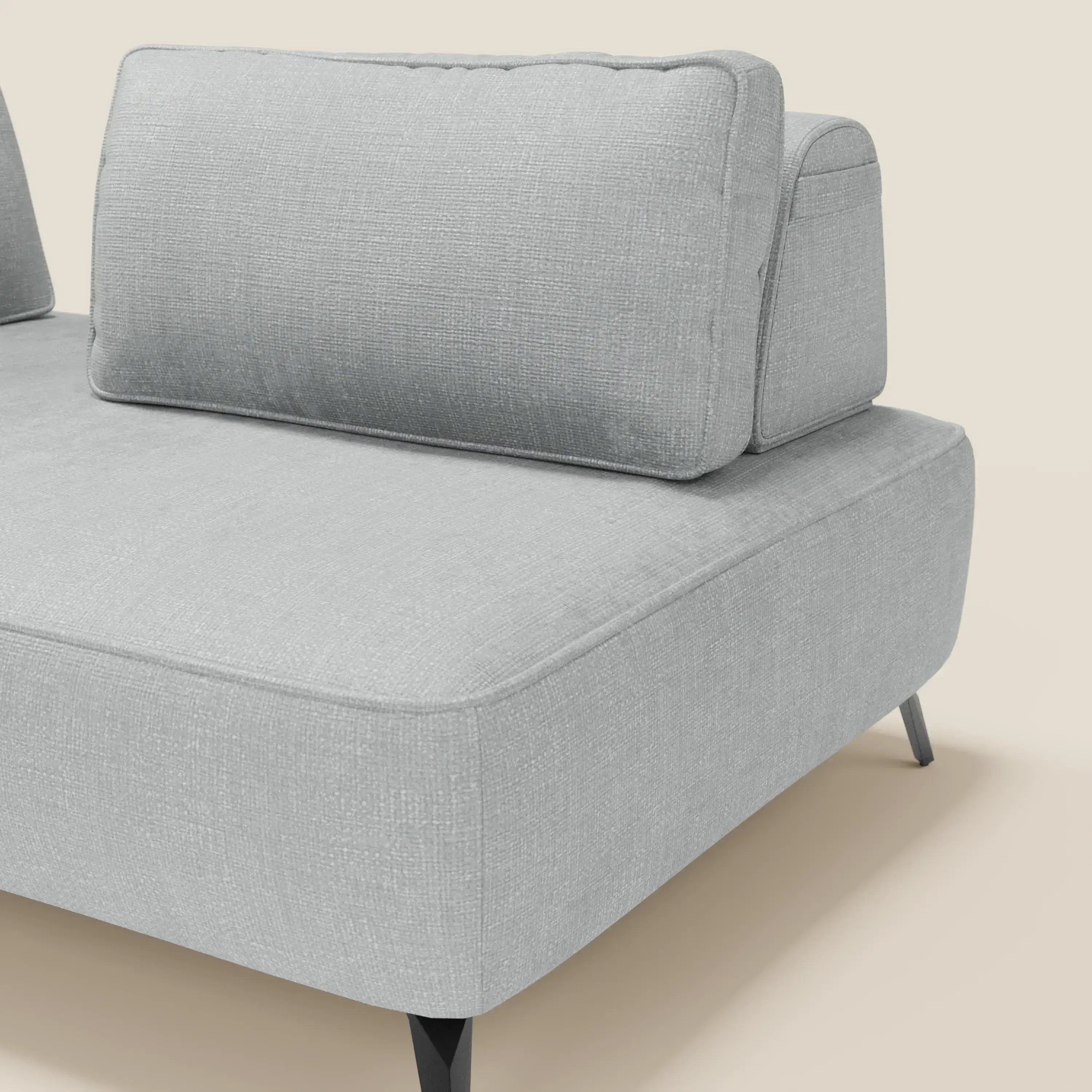 Il divano modulare Volta con schienali mobili in raffinato tessuto ciniglia T06 ghiaccio di Divani.Store è caratterizzato da un ampio cuscino di seduta, schienali mobili angolati e gambe nere affusolate, che si stagliano su un semplice sfondo bianco sporco.