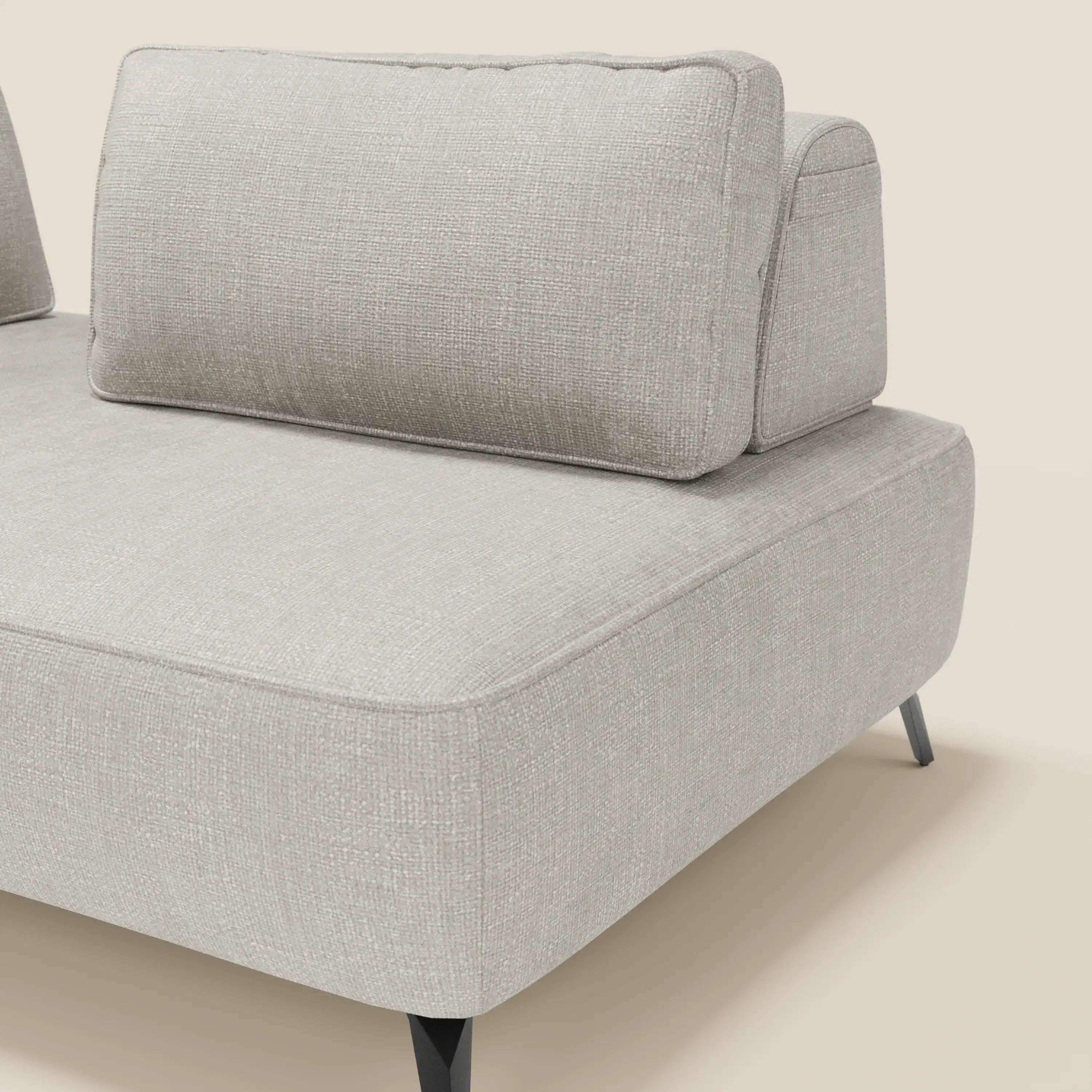 Primo piano del divano modulare Volta di Divani.Store, caratterizzato da schienali mobili, raffinato tessuto ciniglia T06 grigio chiaro, due cuscini di schienale, sottili gambe angolari nere e una texture morbida su uno sfondo bianco sporco.