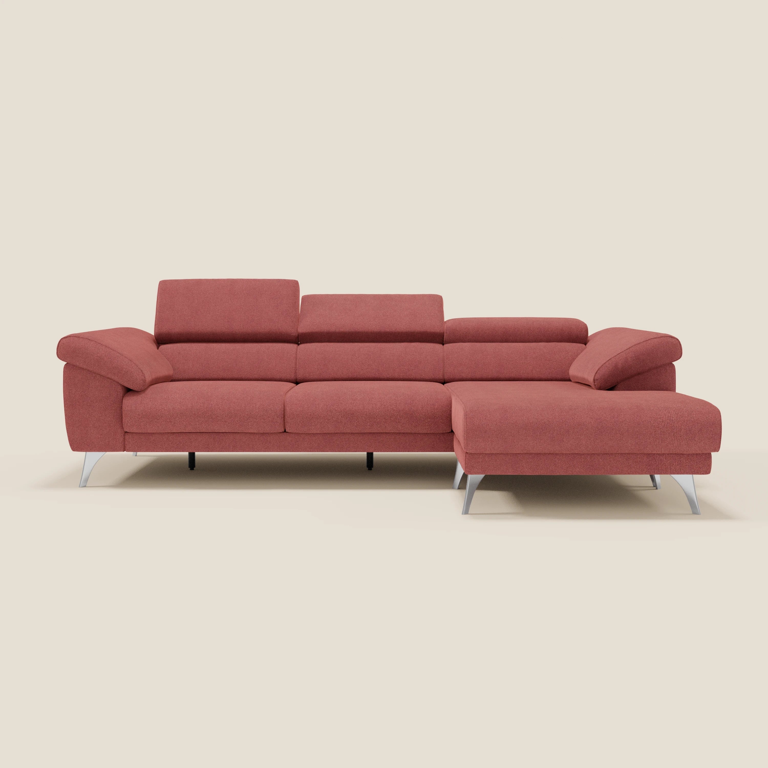 Il divano angolare Donatello di Divani.Store in smacchiabile T23 rosso ciliegia è caratterizzato da sedute scorrevoli, braccioli contenitori e poggiatesta regolabili. In un'immagine su sfondo panna, la chaise si estende a destra.