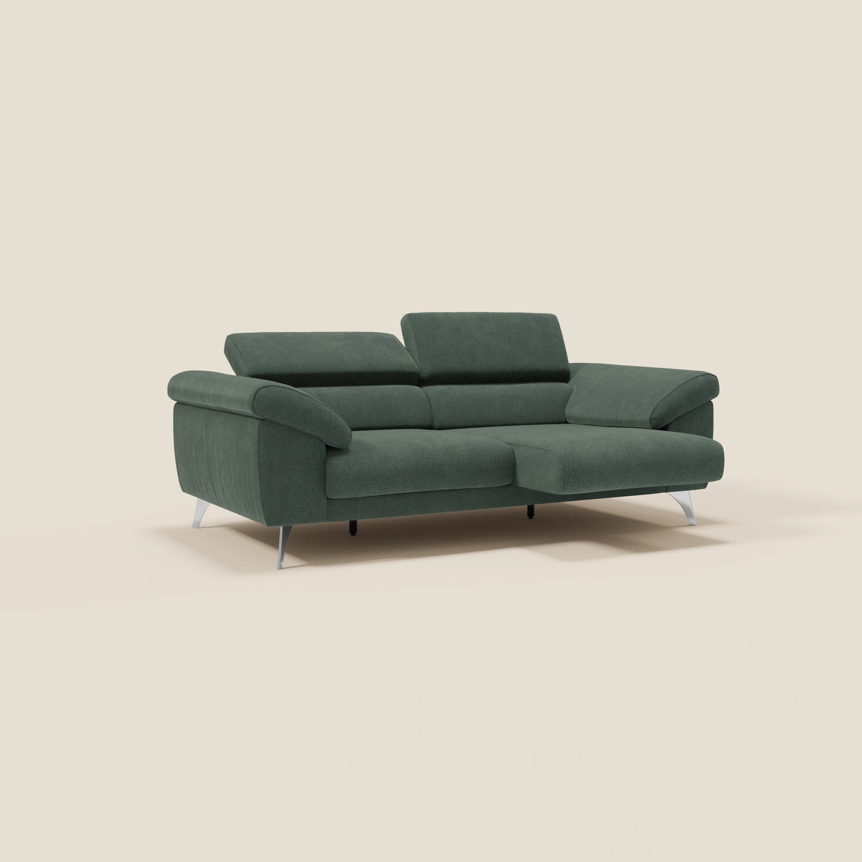 Il divano Donatello di Divani.Store, in tessuto antimacchia verde T23, è dotato di sedute allungabili, braccioli contenitori e poggiatesta reclinabili. Il suo design a L offre un comfort moderno, in questo caso su uno sfondo beige semplice.