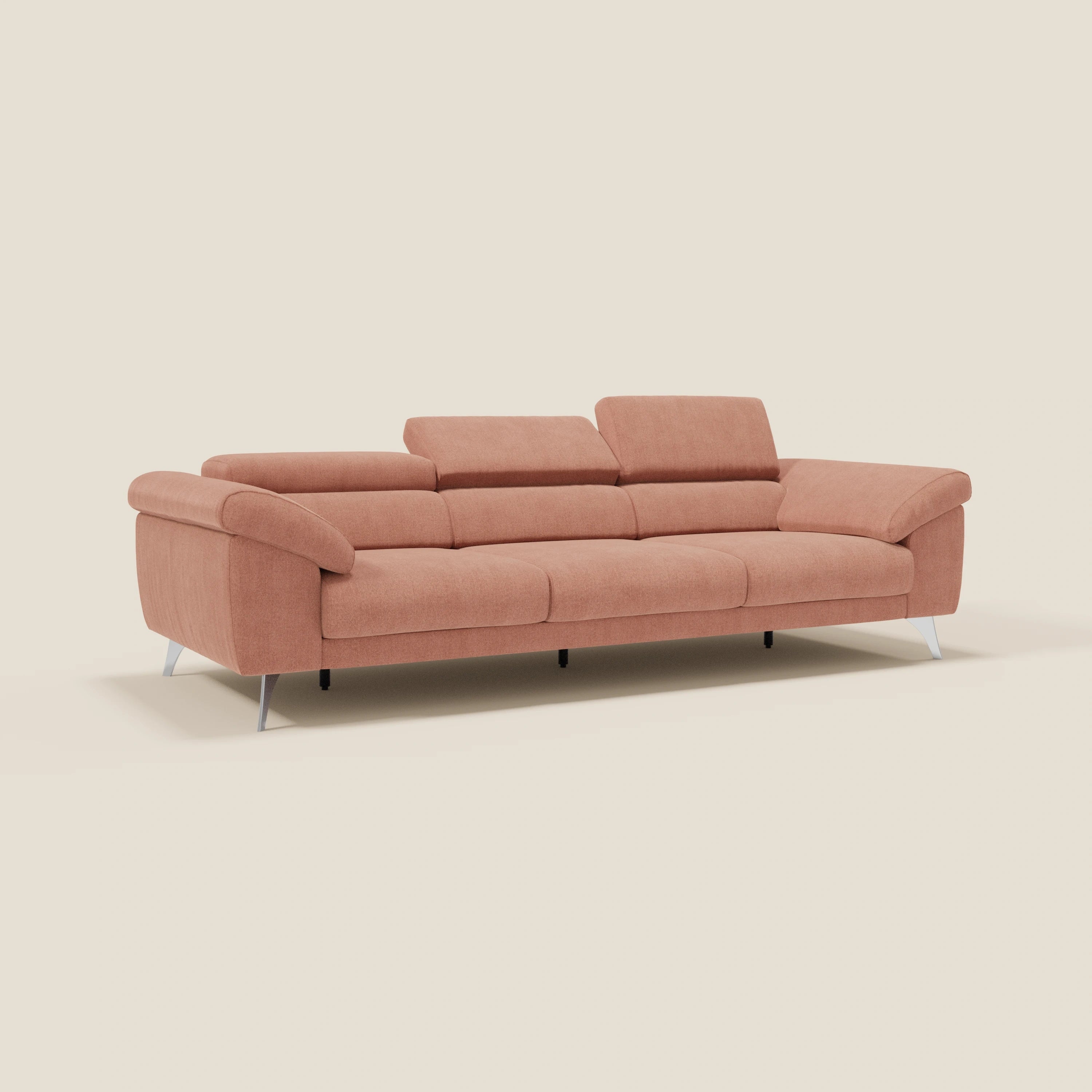 Il divano contemporaneo Donatello di Divani.Store, in tessuto smacchiabile T23 pesca, è caratterizzato da 3 sedute estensibili, braccioli contenitori e poggiatesta reclinabili con eleganti gambe argentate, su uno sfondo beige chiaro.