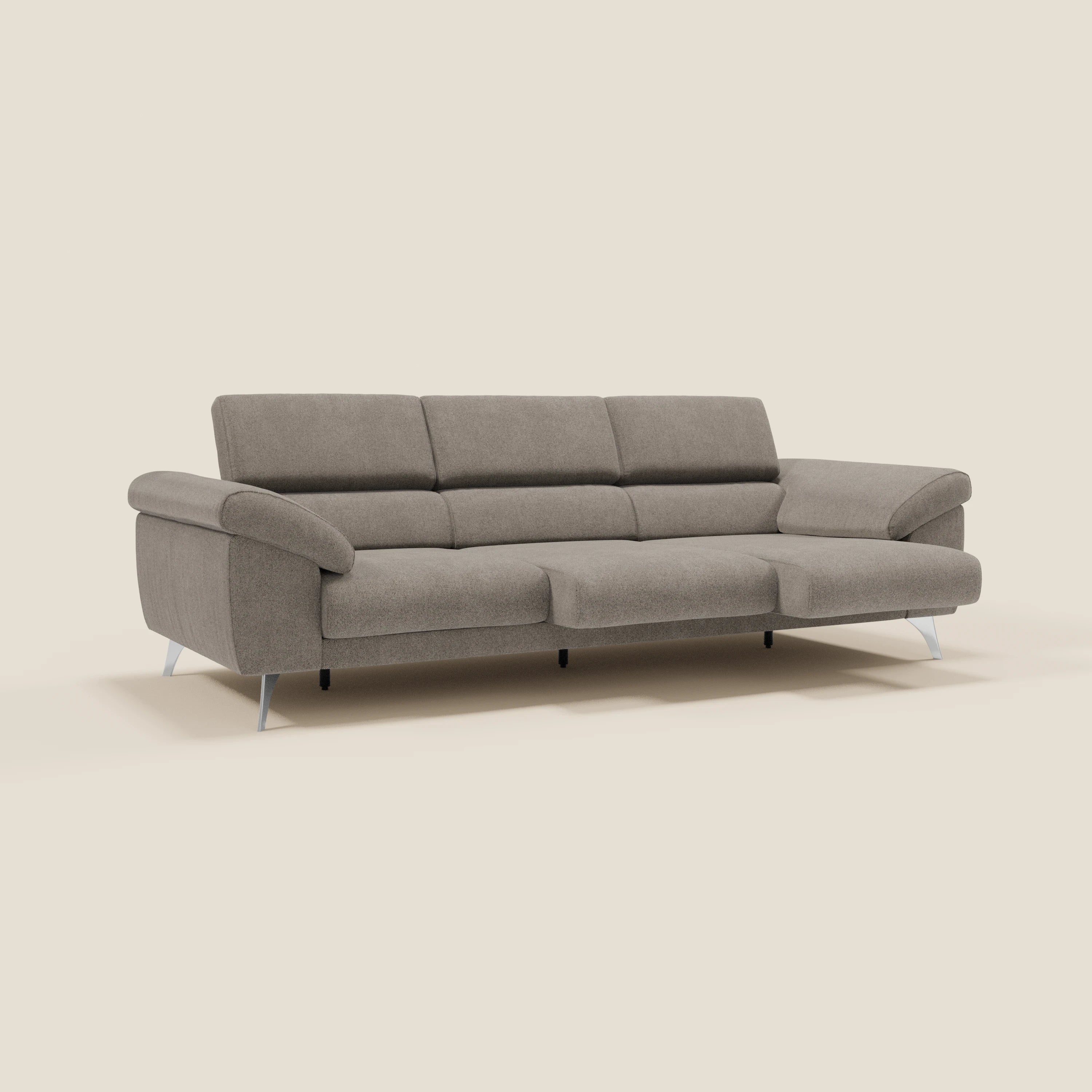 Il divano Donatello di Divani.Store è dotato di 3 sedute estensibili, braccioli contenitori e poggiatesta reclinabili in tessuto antimacchia T23 taupe. Il suo design moderno si staglia su uno sfondo beige semplice, con morbidi pannelli imbottiti sullo schienale.