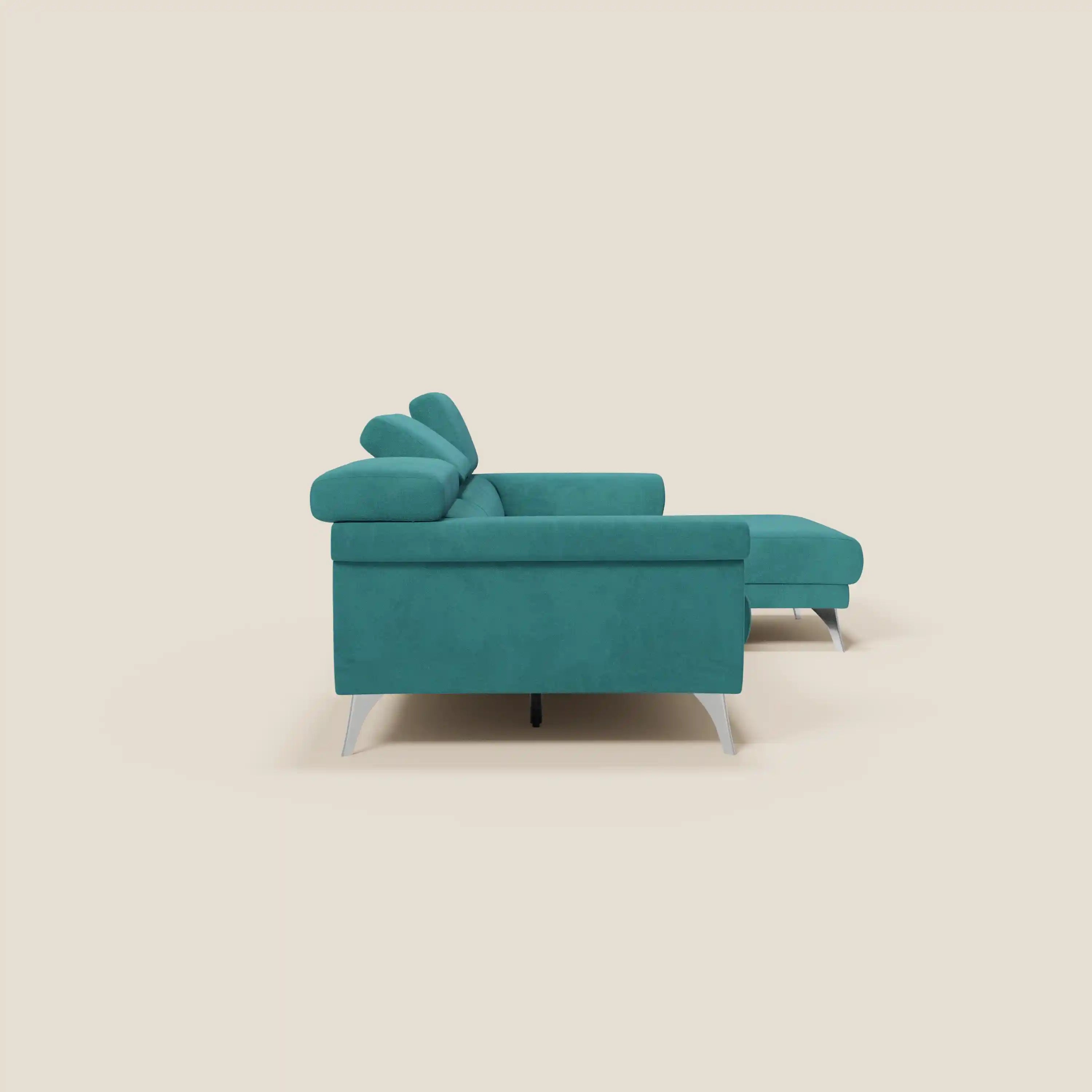 Il divano angolare Raffaello di Divani.Store in microfibra petrolio T11 è caratterizzato da sedute scorrevoli, poggiatesta regolabili, cuscini morbidi e chaise longue destra, il tutto appoggiato su gambe angolari in metallo su uno sfondo beige chiaro.