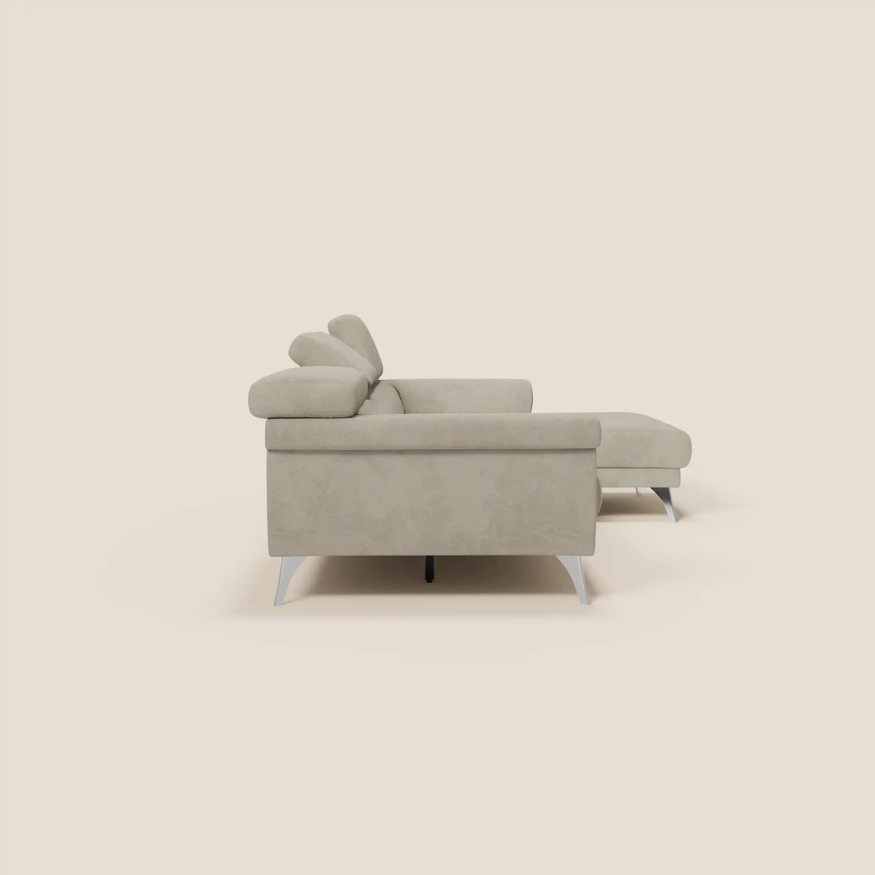 Il Divano angolare Raffaello di Divani.Store è caratterizzato da sedute scorrevoli, poggiatesta regolabili ed eleganti gambe metalliche in microfibra antimacchia T11 tortora, raffigurata lateralmente su uno sfondo bianco sporco con cuscini morbidi e linee pulite.