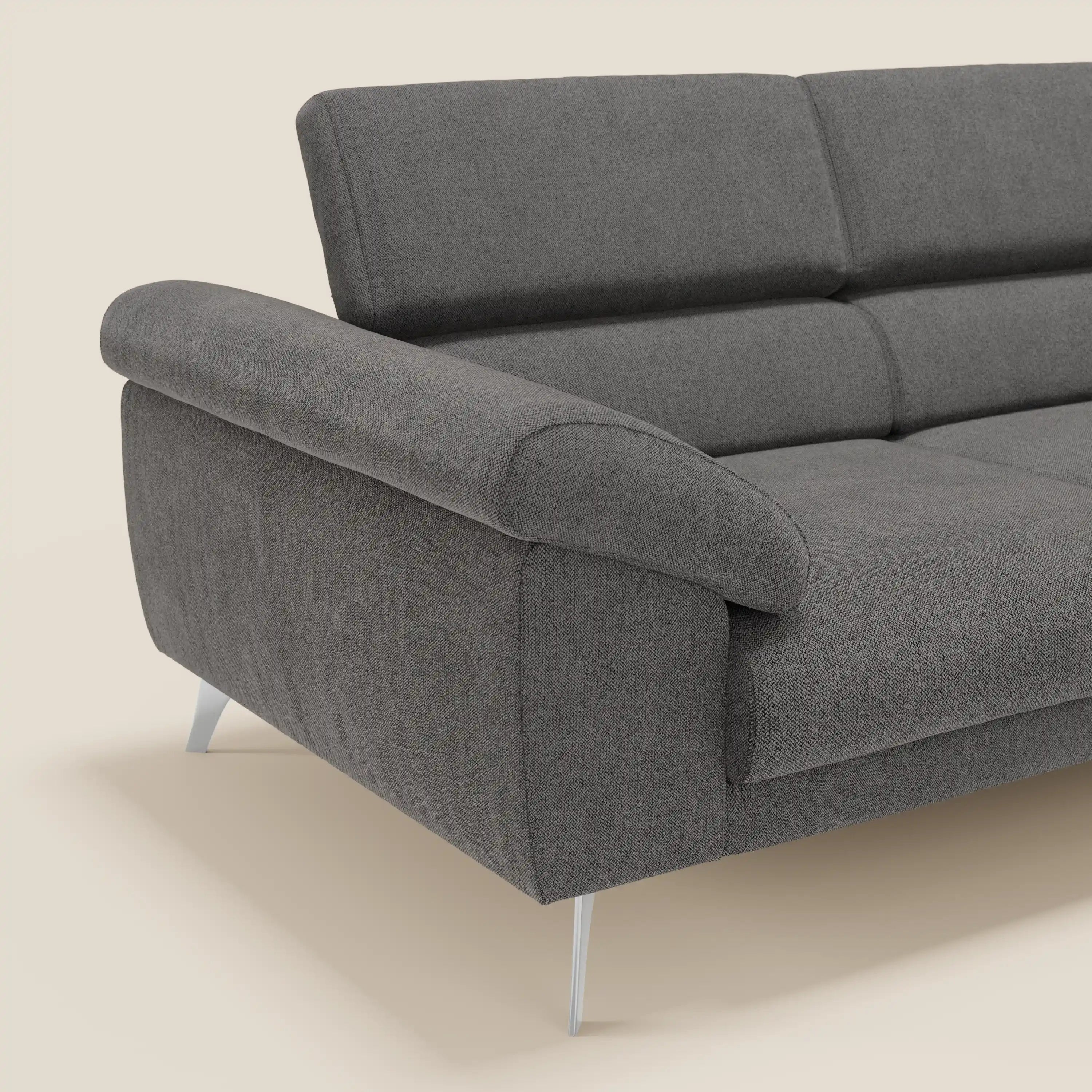 Il divano Donatello di Divani.Store è caratterizzato da sedute allungabili, braccioli contenitore e poggiatesta reclinabili in tessuto T23 antracite smacchiabile. In primo piano su sfondo chiaro, con gambe in metallo e parte della seduta e dello schienale visibili.