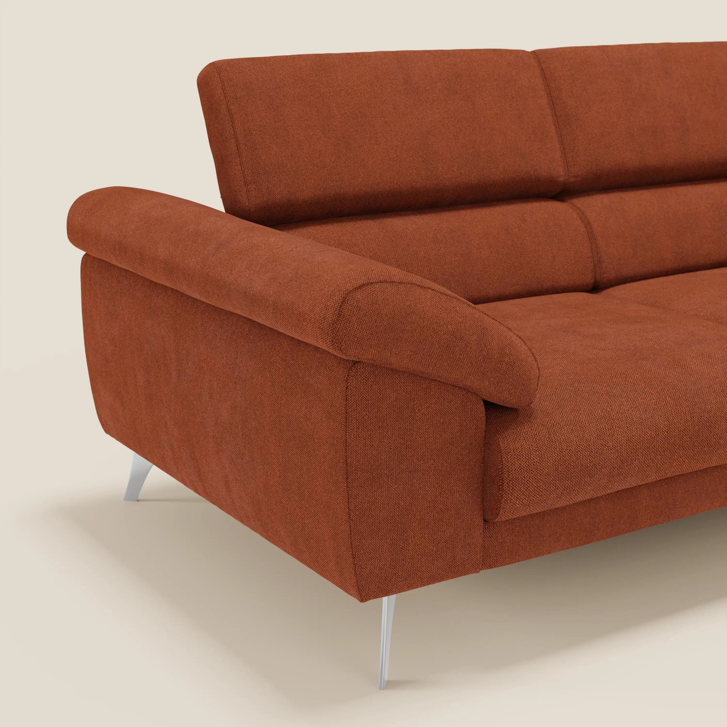Divano Donatello di Divani.Store in tessuto arancione ruggine T23 smacchiabile, con sedute allungabili, braccioli contenitore e poggiatesta reclinabili. Solo un angolo è mostrato su uno sfondo chiaro per evidenziare il suo design moderno.