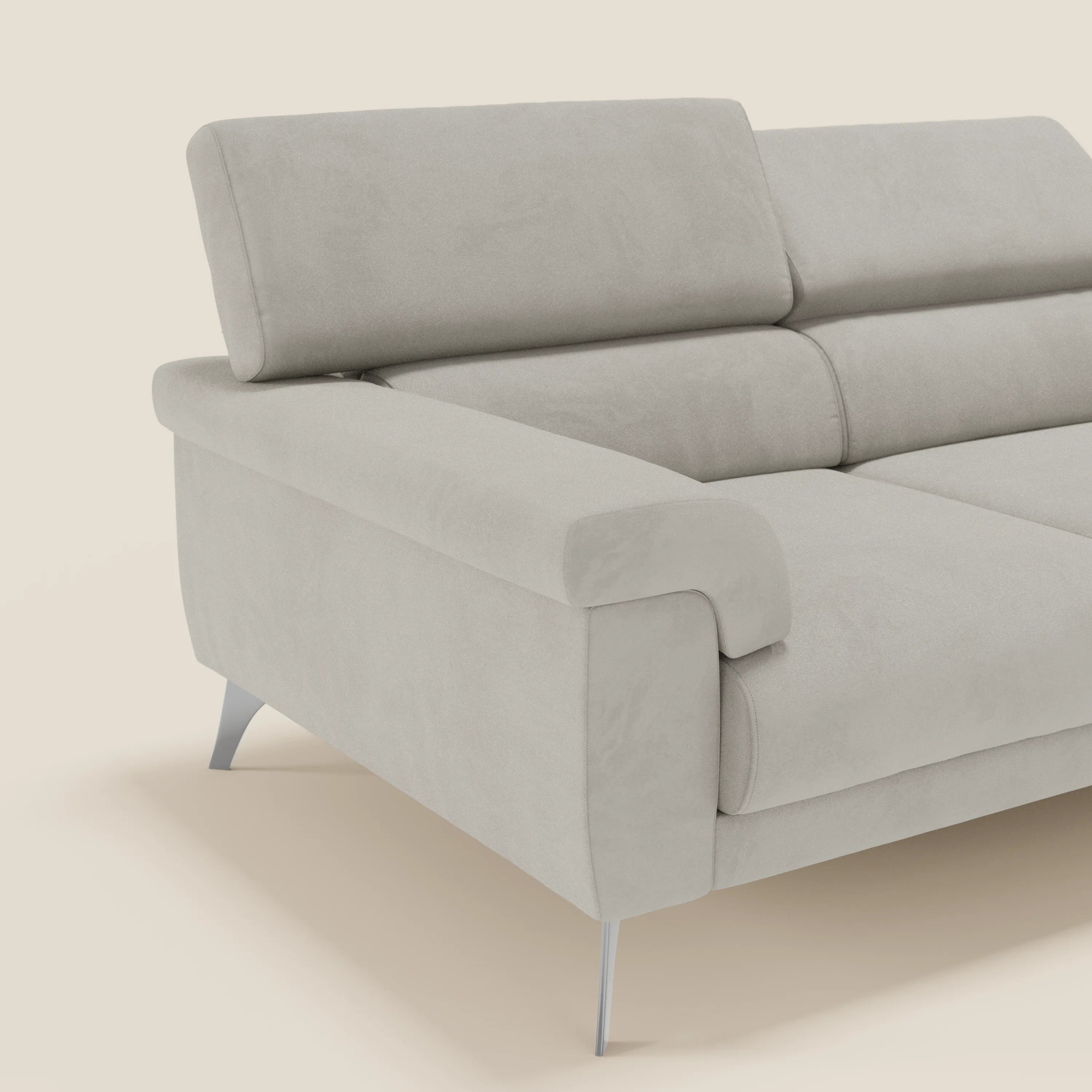 Su un semplice sfondo bianco sporco, il divano Raffaello di Divani.Store presenta 3 sedute allungabili e poggiatesta reclinabili in microfibra panna T11 antimacchia. Di questo divano moderno con ampi braccioli e gambe in metallo è visibile solo una parte.