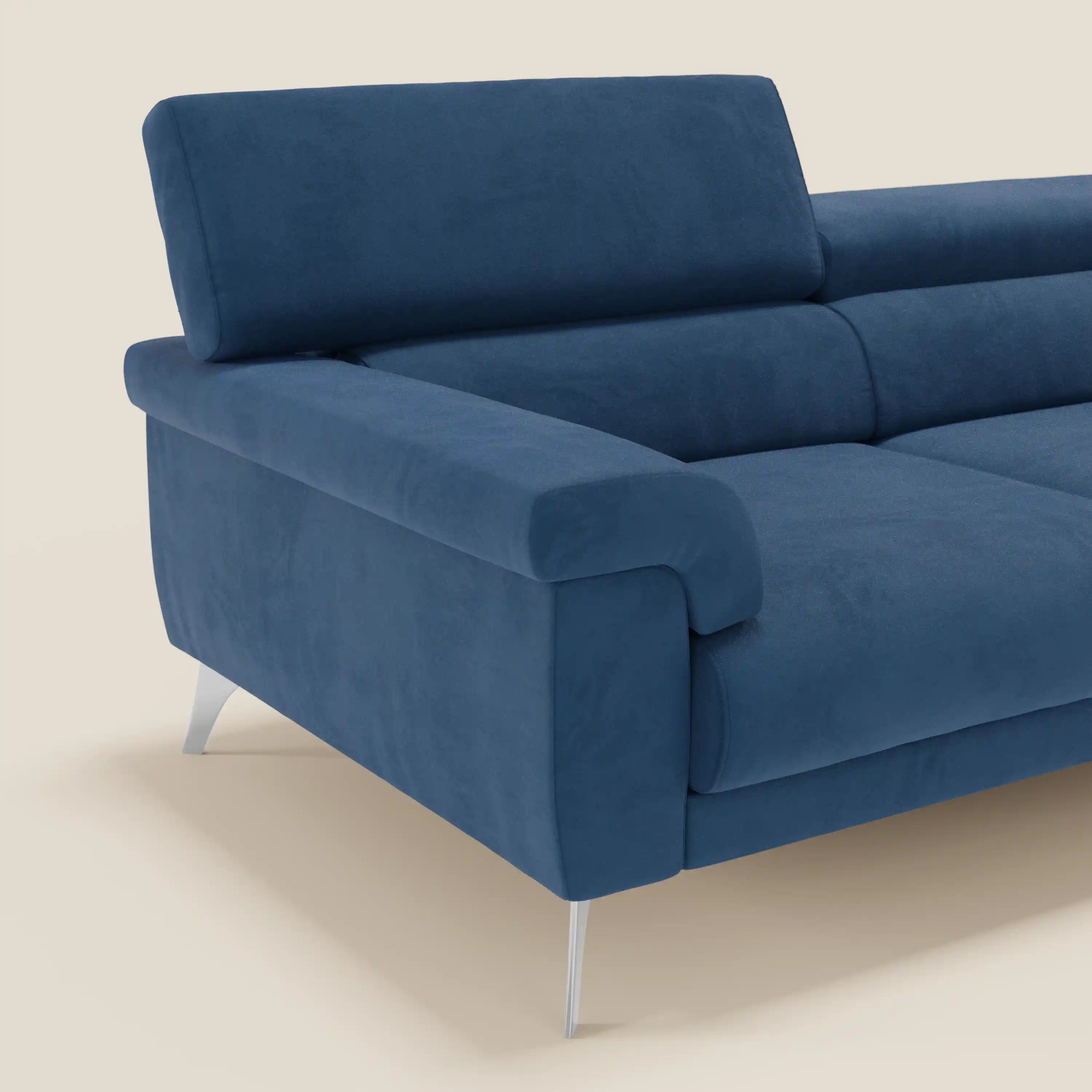 Il divano Raffaello di Divani.Store, in smacchiabile T11 blu microfibra, è caratterizzato da sedute allungabili, poggiatesta reclinabili e da un design moderno ed elegante con ampi braccioli e sottili gambe in metallo, su uno sfondo beige chiaro.