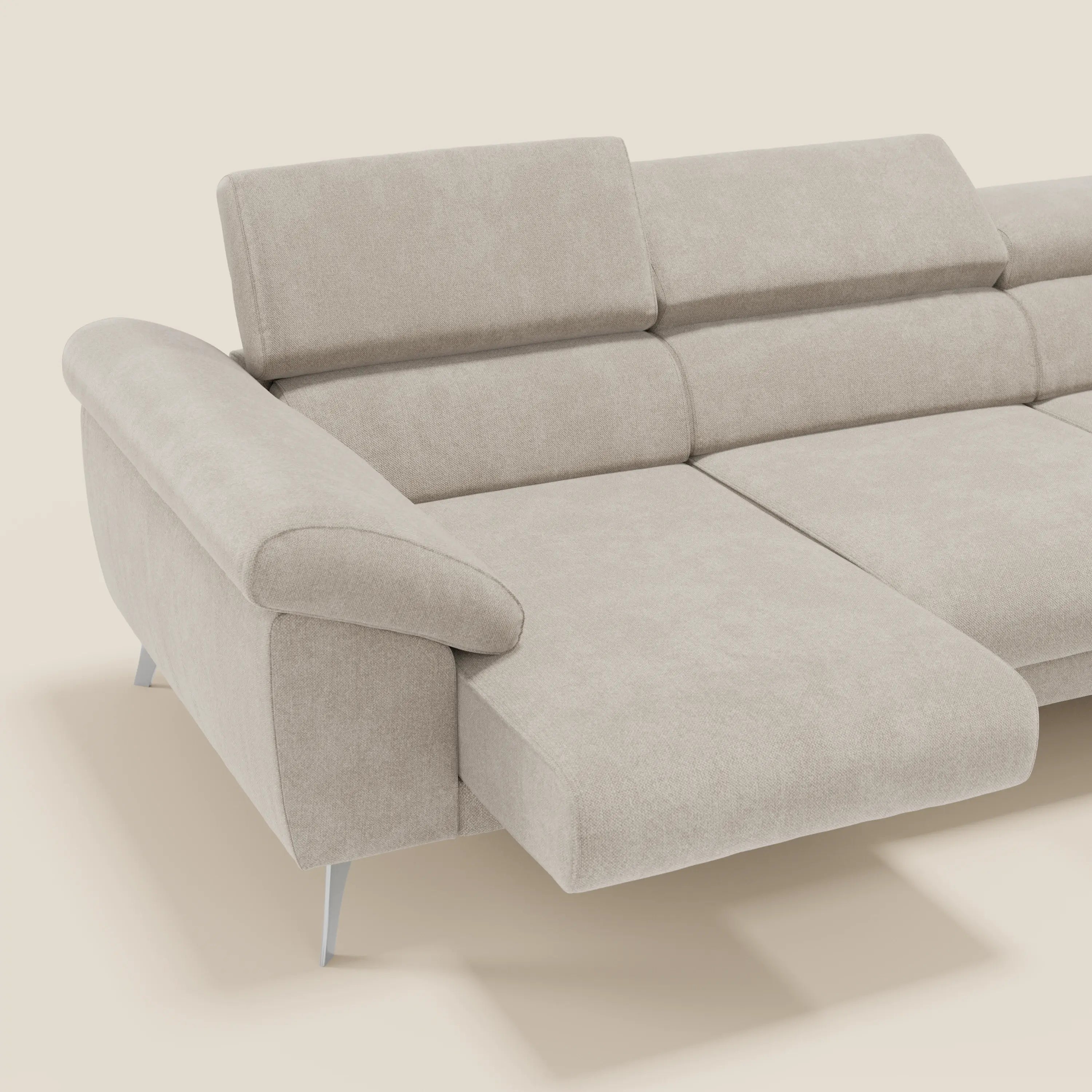 Il divano angolare Donatello di Divani.Store è rivestito in morbido tessuto panna T23 antimacchia ed è dotato di poggiatesta regolabile, ampi braccioli portaoggetti, gambe angolari in metallo, chaise lounge e sedute scorrevoli per un comfort su misura. Sfondo bianco sporco a tinta unita.