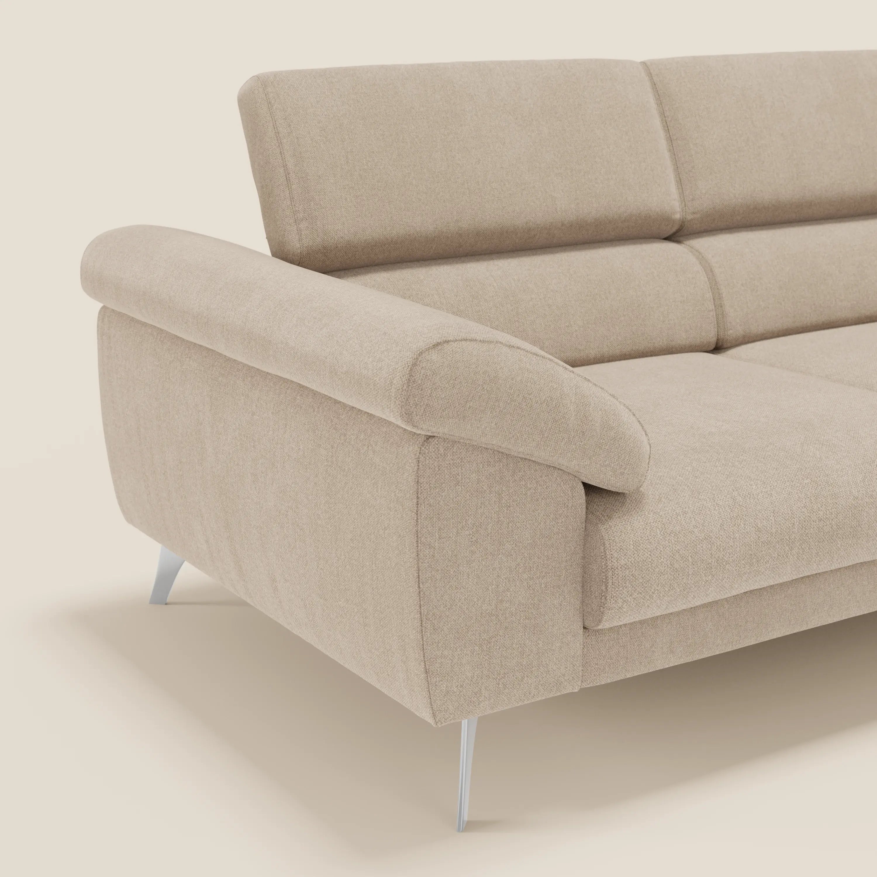 Il divano Donatello di Divani.Store, in tessuto antimacchia T23 beige, è caratterizzato da sedute allungabili, braccioli contenitori e poggiatesta reclinabili. Il suo design moderno e minimalista, con gambe argentate, spicca su uno sfondo bianco sporco; solo un angolo è visibile.