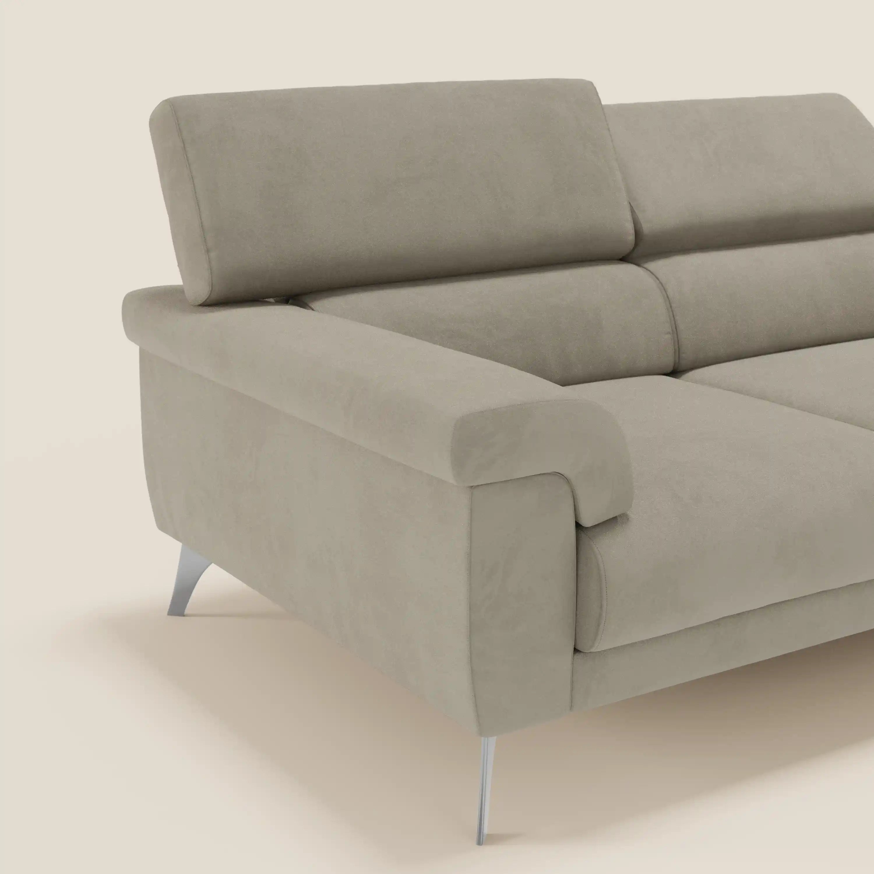 Divano Raffaello con 3 sedute allungabili e poggiatesta reclinabile in microfibra smacchiabile T11 tortora di Divani.Store è presentato con ampi braccioli e gambe angolate cromate su sfondo crema; parte del divano è visibile.