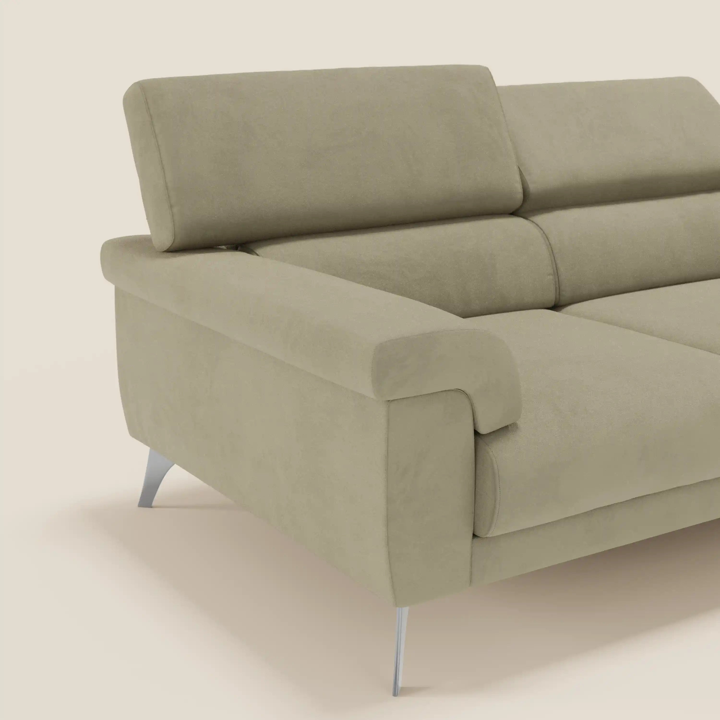 Un moderno divano Raffaello beige di Divani.Store, con 3 sedute allungabili, poggiatesta reclinabili e microfibra T11 antimacchia. Gli ampi braccioli e le gambe angolari argentate ne evidenziano la qualità artigianale su uno sfondo bianco sporco.