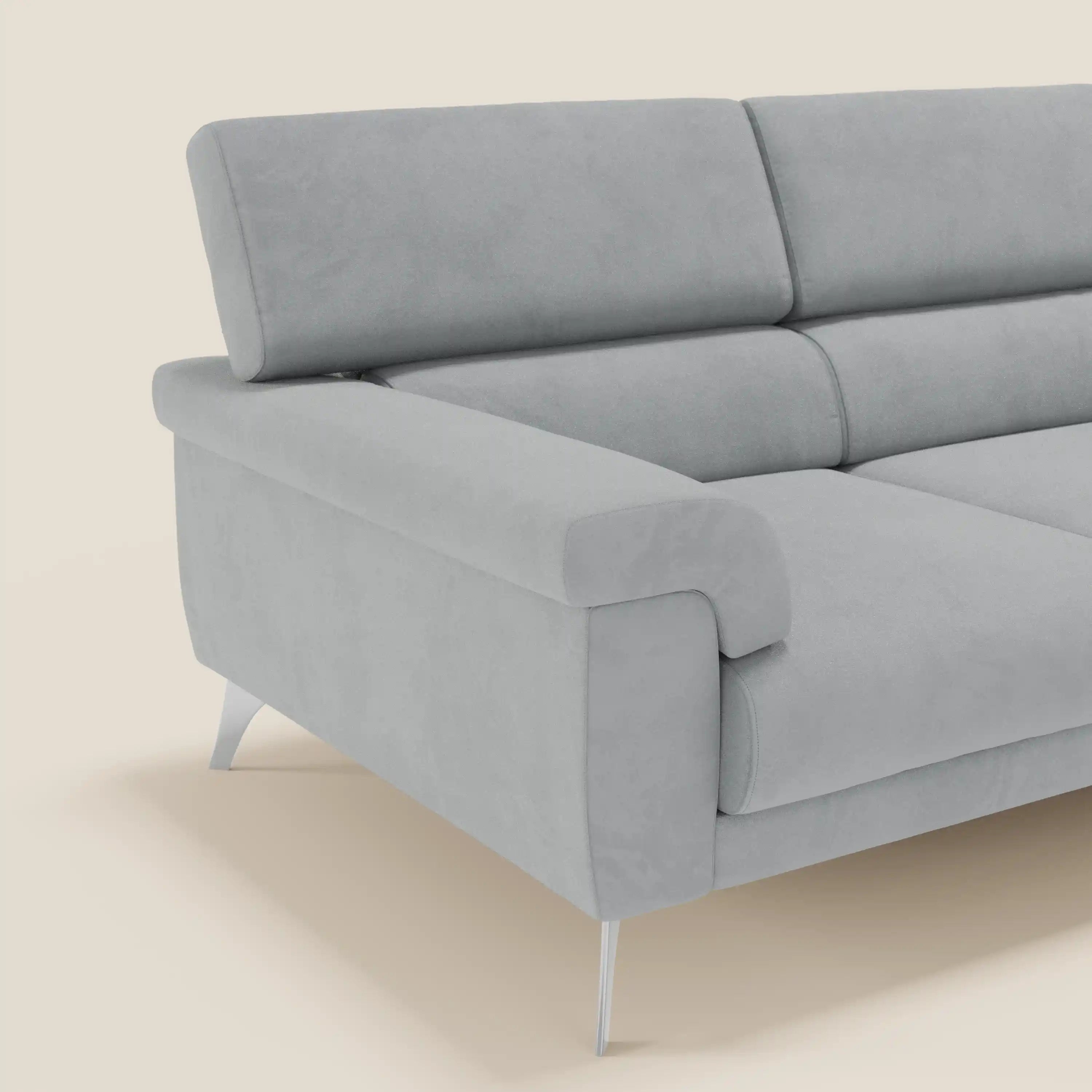 Il Raffaello Divano angolare di Divani.Store in microfibra smacchiabile grigio chiaro T11 è caratterizzato da sedute scorrevoli, poggiatesta regolabili e un look moderno. Il divano spicca su uno sfondo color crema.