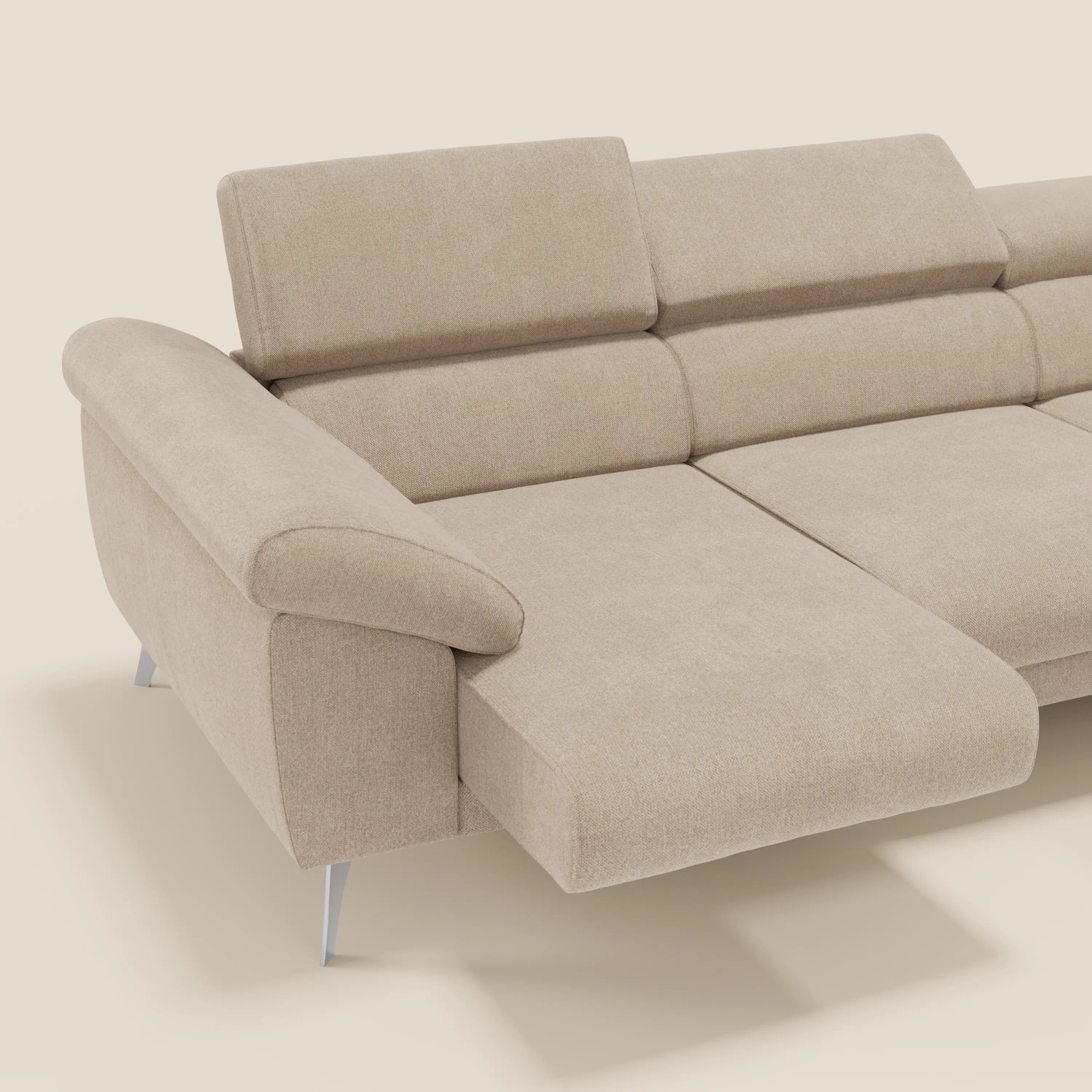 Il Donatello Divano angolare di Divani.Store è caratterizzato da sedute scorrevoli, braccioli contenitore, poggiatesta regolabili e morbido tessuto T23 beige antimacchia. La sua forma a L si staglia su un semplice sfondo bianco sporco per un fascino moderno.