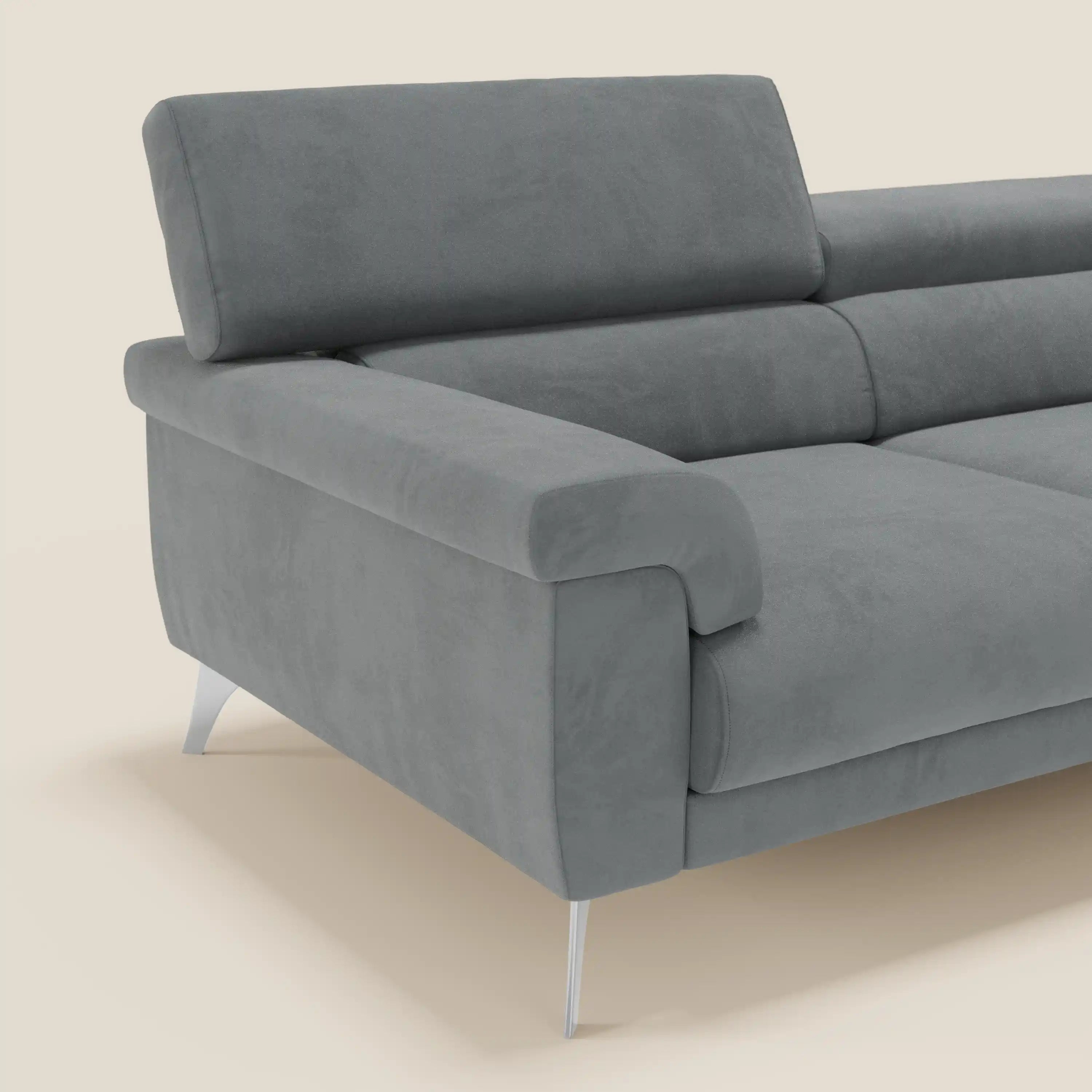 Il divano Raffaello di Divani.Store è caratterizzato da sedute allungabili, poggiatesta reclinabili e rivestimento in microfibra grigio T11 facile da pulire. Il design moderno con ampi braccioli e gambe in metallo si staglia su uno sfondo beige chiaro, mostrando un'estremità del divano.