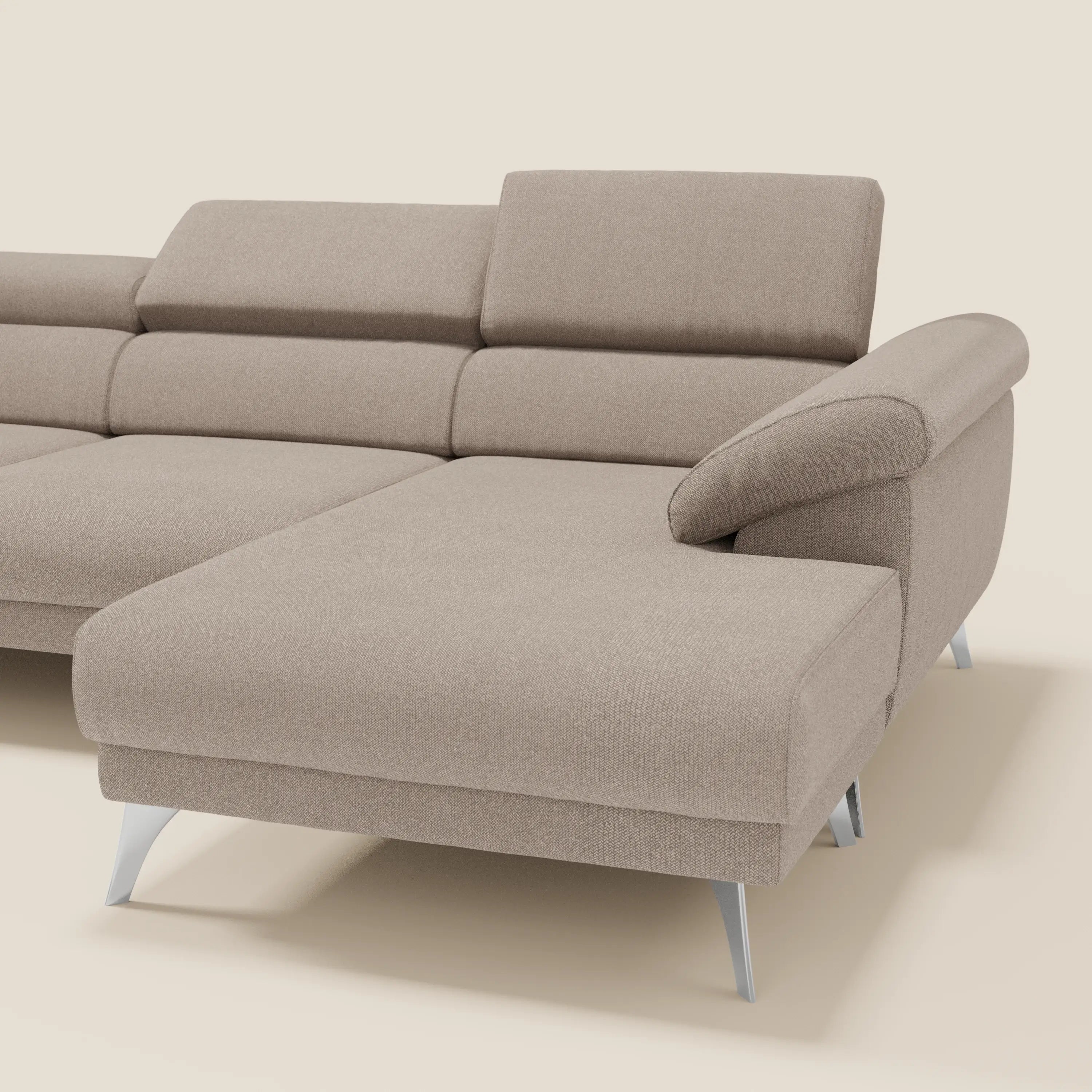 Il Donatello Divano angolare di Divani.Store è un divano a L in tortora T23 in morbido tessuto antimacchia, con sedute scorrevoli, braccioli portaoggetti e poggiatesta regolabili, con chaise lounge a destra su sfondo chiaro.