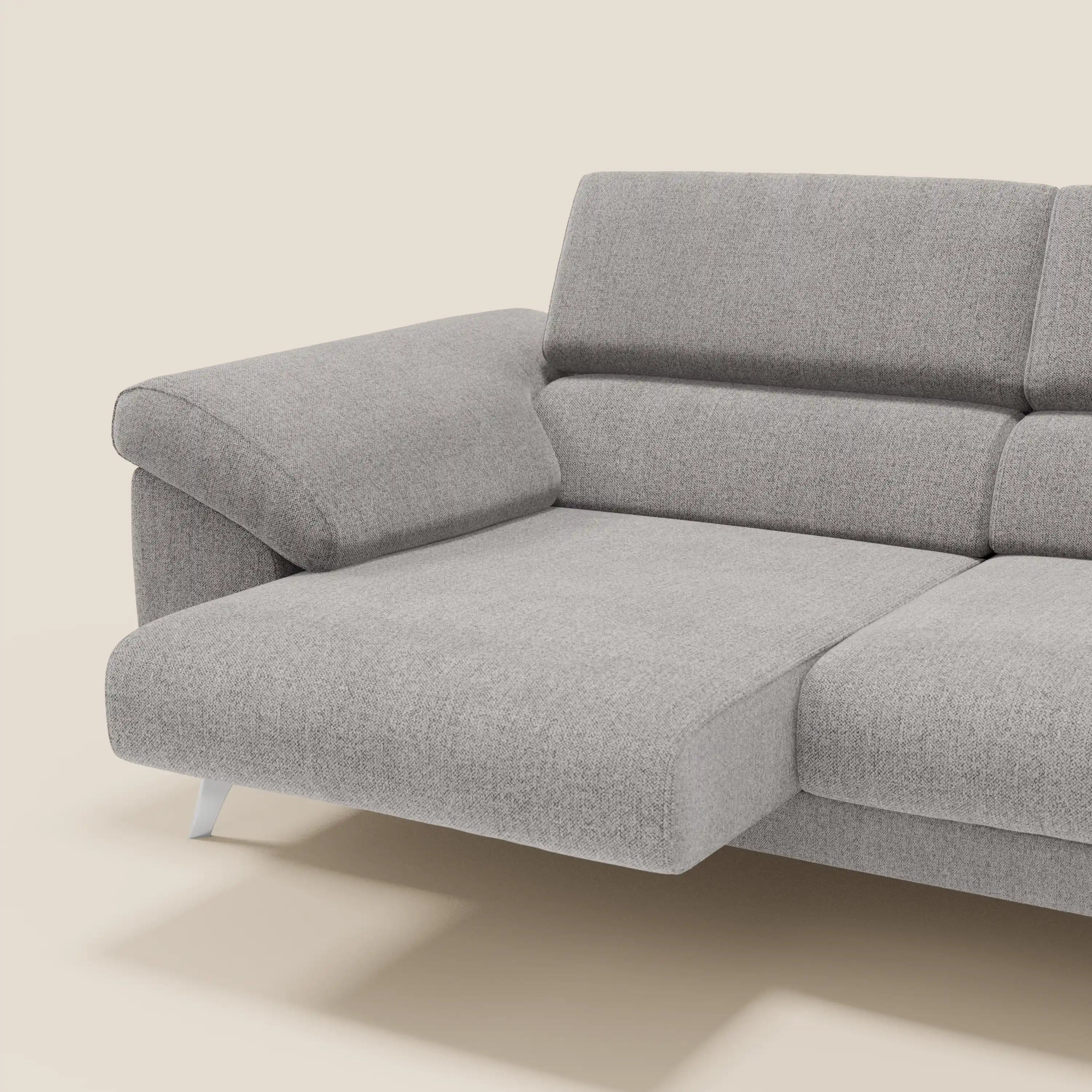 Il divano Donatello di Divani.Store in tessuto smacchiabile T23 grigio, con sedute allungabili, braccioli contenitore e poggiatesta reclinabili, offre massimo comfort e design moderno contro uno sfondo beige.