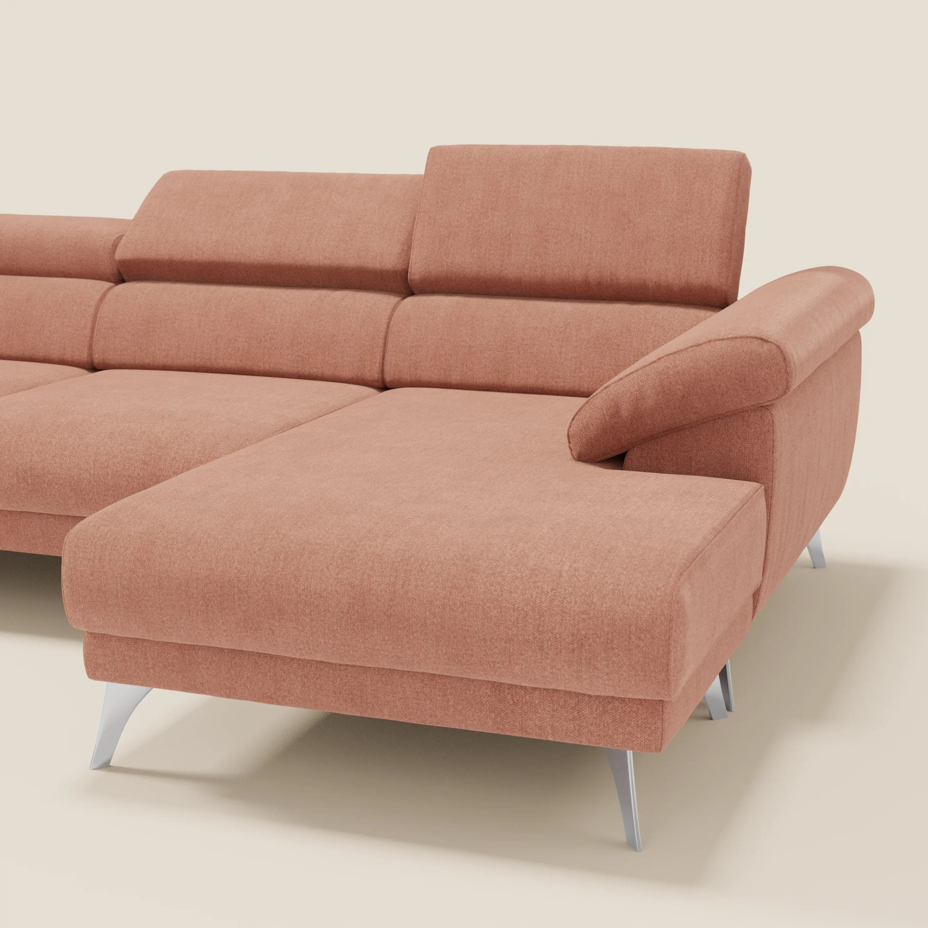 Il Donatello Divano angolare di Divani.Store in morbido tessuto antimacchia T23 pesca è dotato di poggiatesta regolabile, bracciolo destro portaoggetti, ampie sedute scorrevoli e gambe angolari in metallo argentato. Presentato su sfondo beige chiaro.