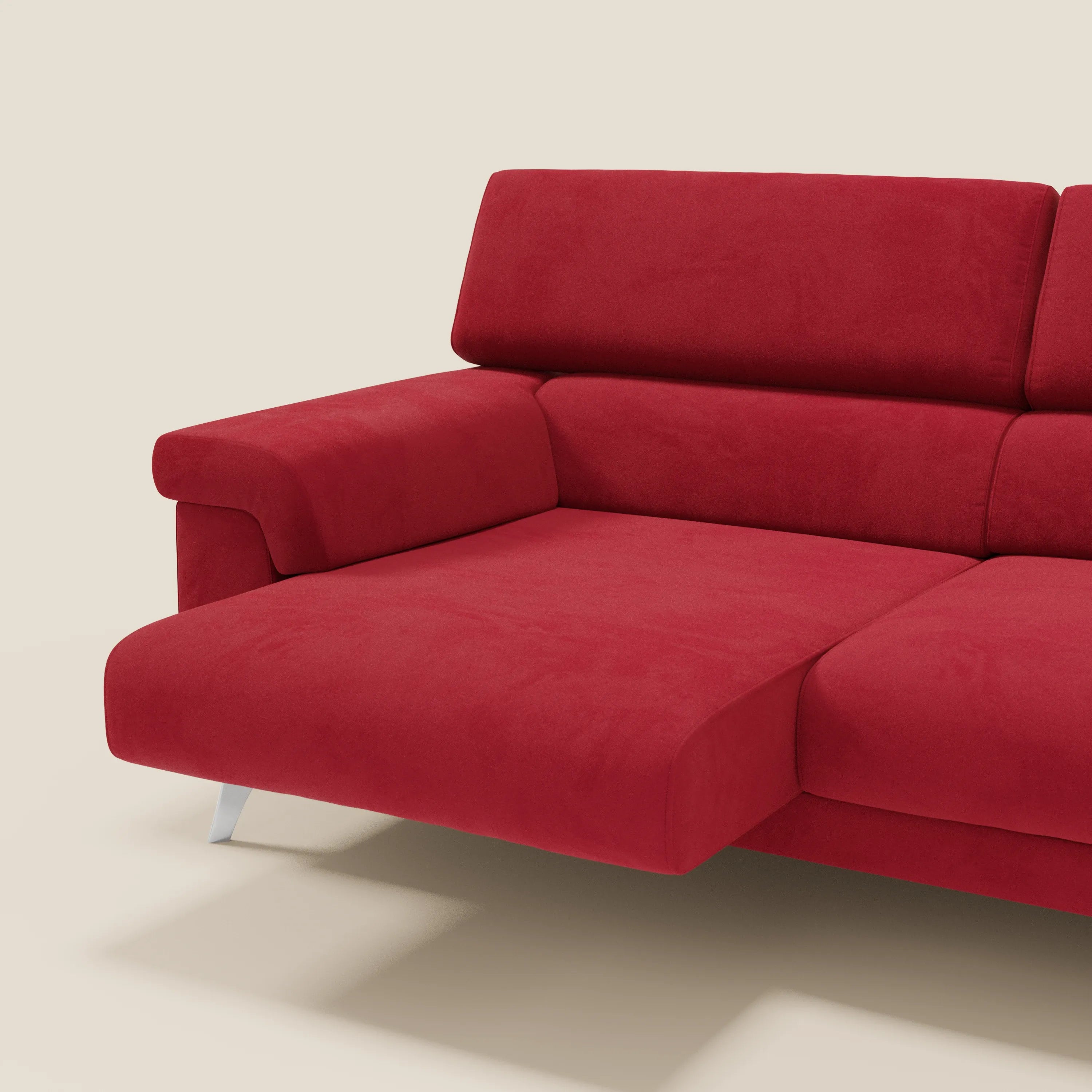 Il divano componibile Raffaello di Divani.Store, in microfibra rossa T11 antimacchia, è caratterizzato da sedute allungabili, poggiatesta regolabili, chaise longue sinistra, ampi braccioli e gambe in metallo argentato su sfondo beige. Viene mostrata solo una parte.