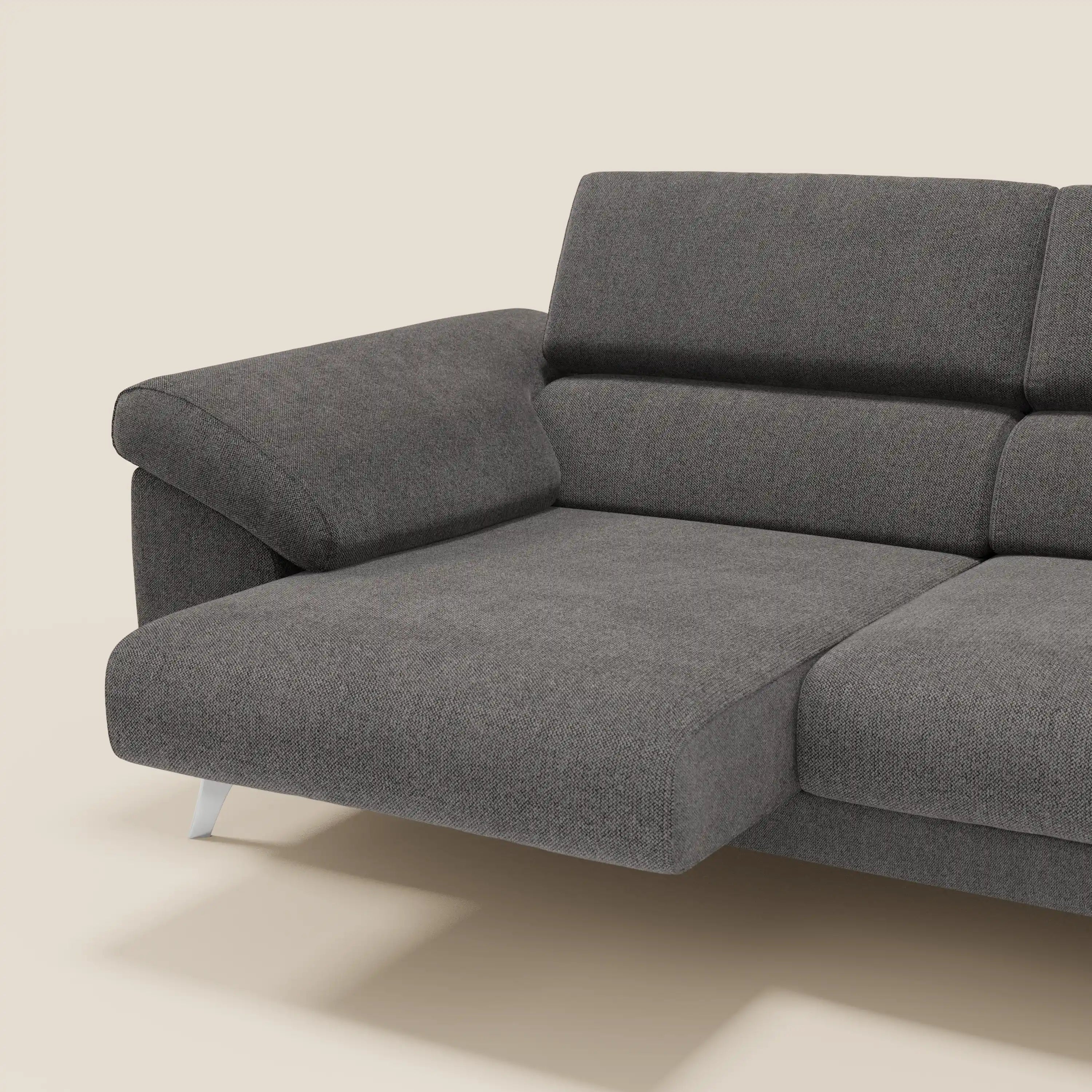 Il divano Donatello di Divani.Store è caratterizzato da sedute allungabili, braccioli contenitore, poggiatesta reclinabili e tessuto smacchiabile T23 antracite. Il suo design moderno è caratterizzato da linee pulite, ampi braccioli e gambe corte in metallo su uno sfondo bianco sporco.