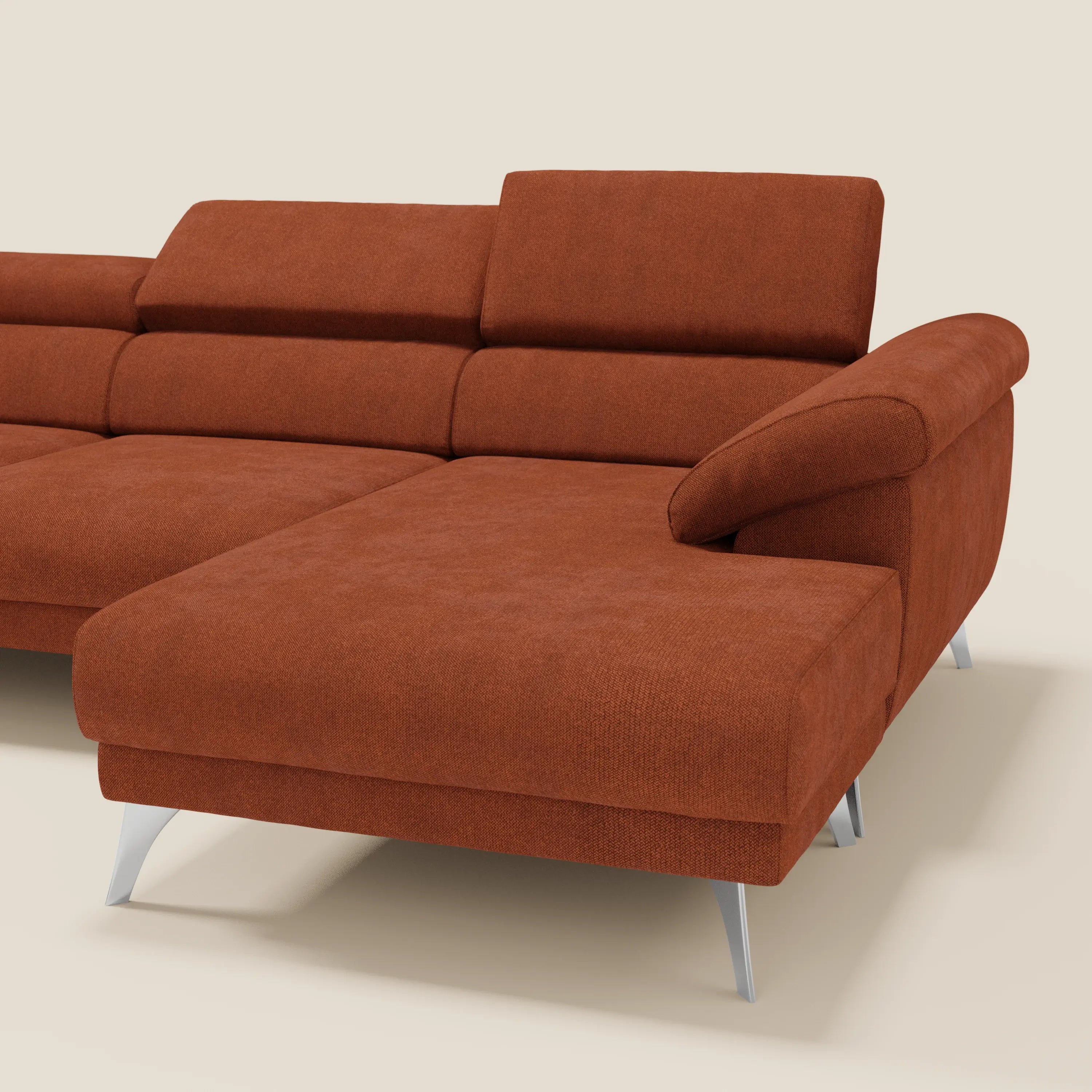 Il Donatello Divano angolare di Divani.Store in T23 arancione ruggine è caratterizzato da sedute scorrevoli, poggiatesta regolabili, braccioli contenitore e poggia su eleganti gambe argentate, su uno sfondo beige chiaro.