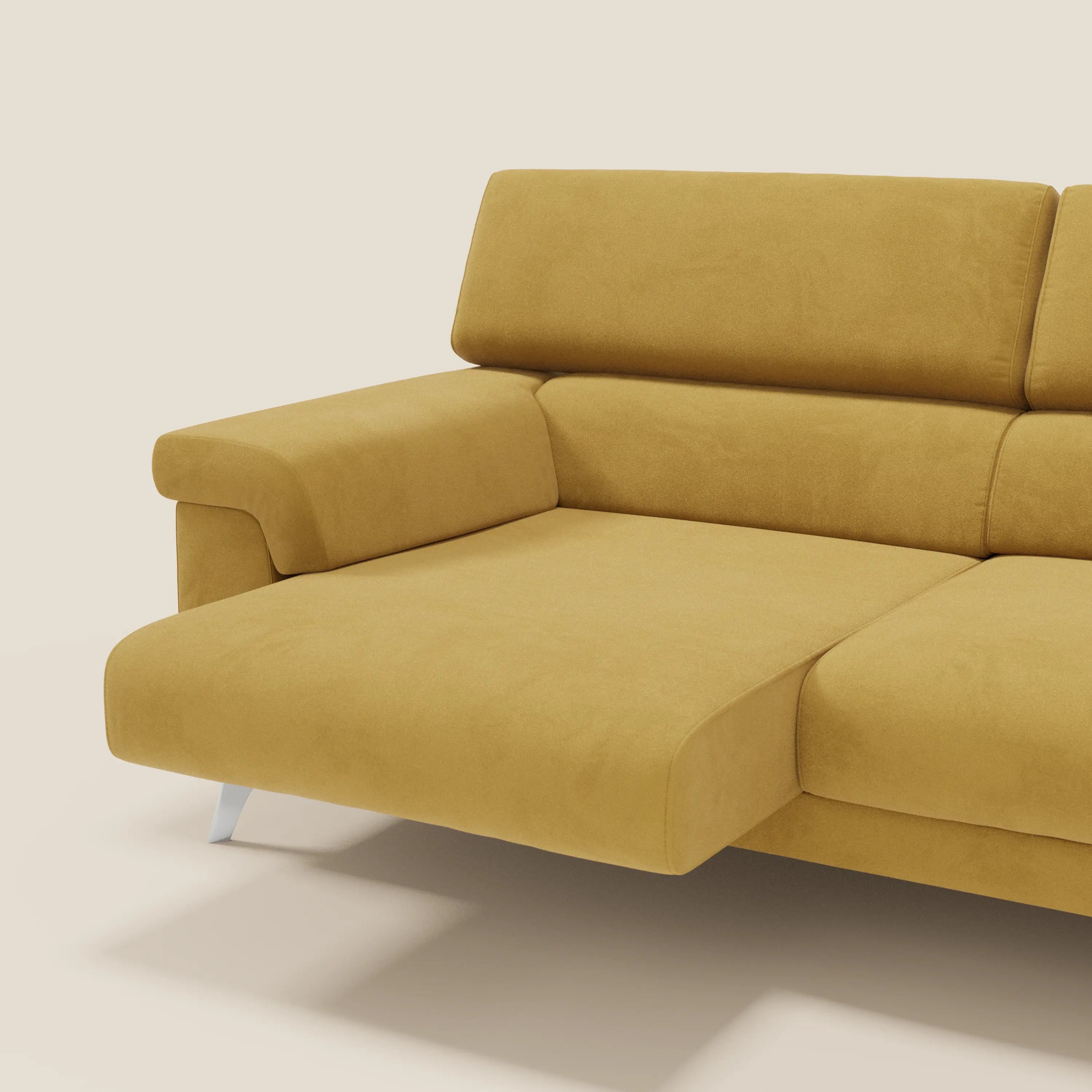 Il divano Raffaello con sedute allungabili e poggiatesta reclinabili in microfibra smacchiabile T11 giallo di Divani.Store è caratterizzato da un moderno effetto chaise lounge con imbottitura in peluche e gambe angolari in metallo, su sfondo beige.