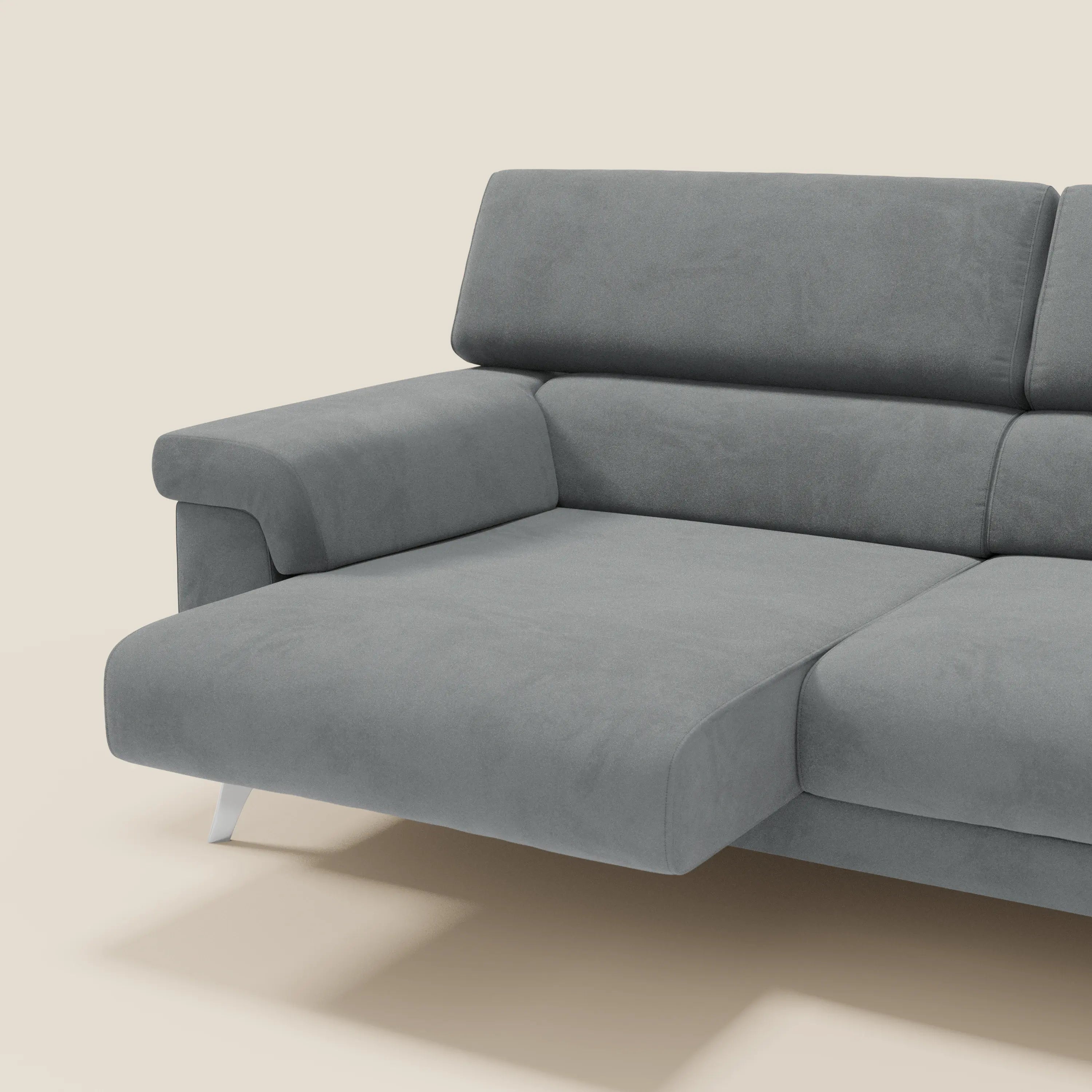 Il divano Raffaello con sedute allungabili e poggiatesta reclinabili in microfibra smacchiabile T11 grigio di Divani.Store è mostrato con chaise longue a sinistra, ampi braccioli, gambe in metallo e schienale imbottito su sfondo beige chiaro.