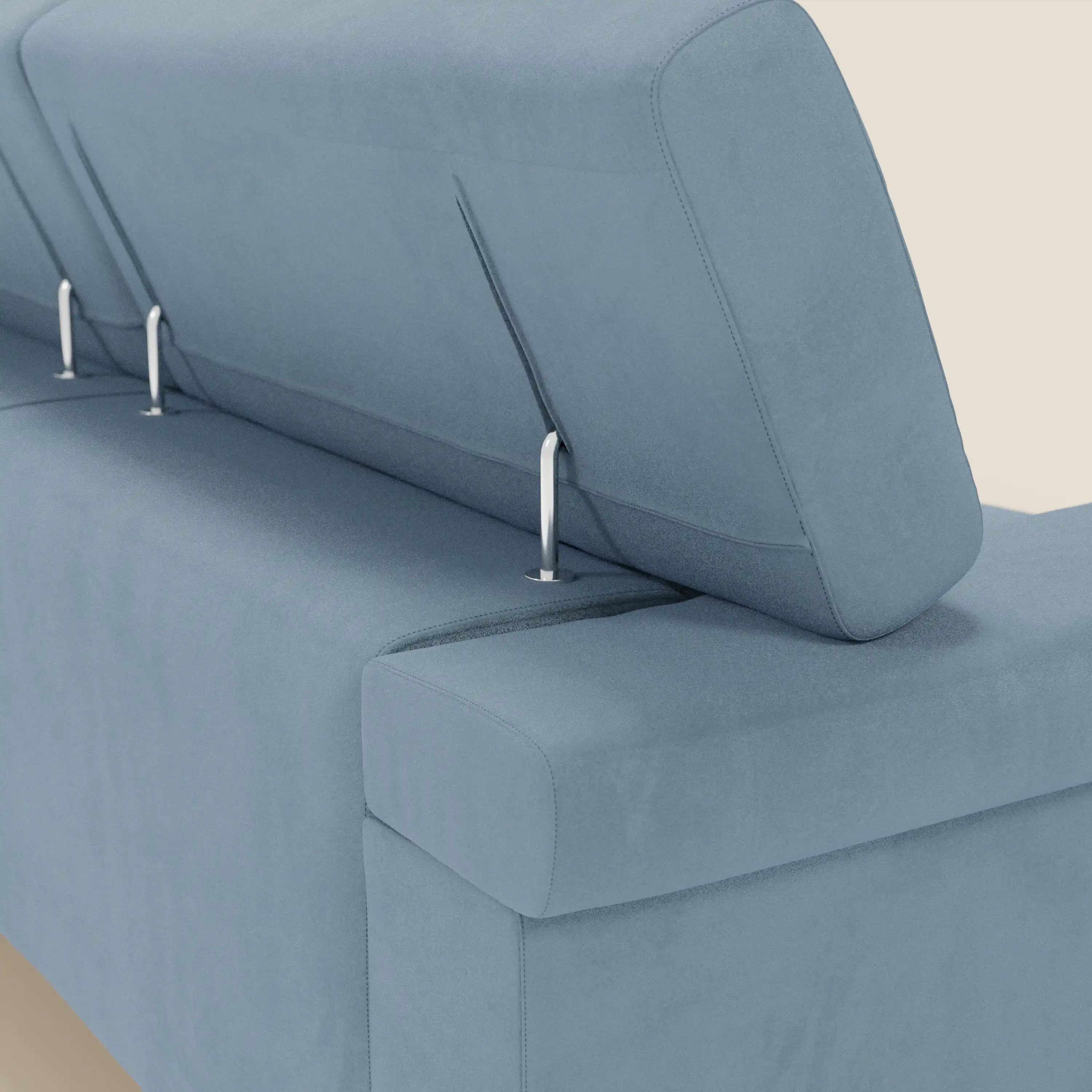 Un primo piano del Raffaello Divano angolare di Divani.Store, caratterizzato da poggiatesta regolabili e sedute scorrevoli in microfibra T11 carta da zucchero, facile da pulire, con eleganti supporti in metallo e cuscini rettangolari su uno sfondo bianco sporco.