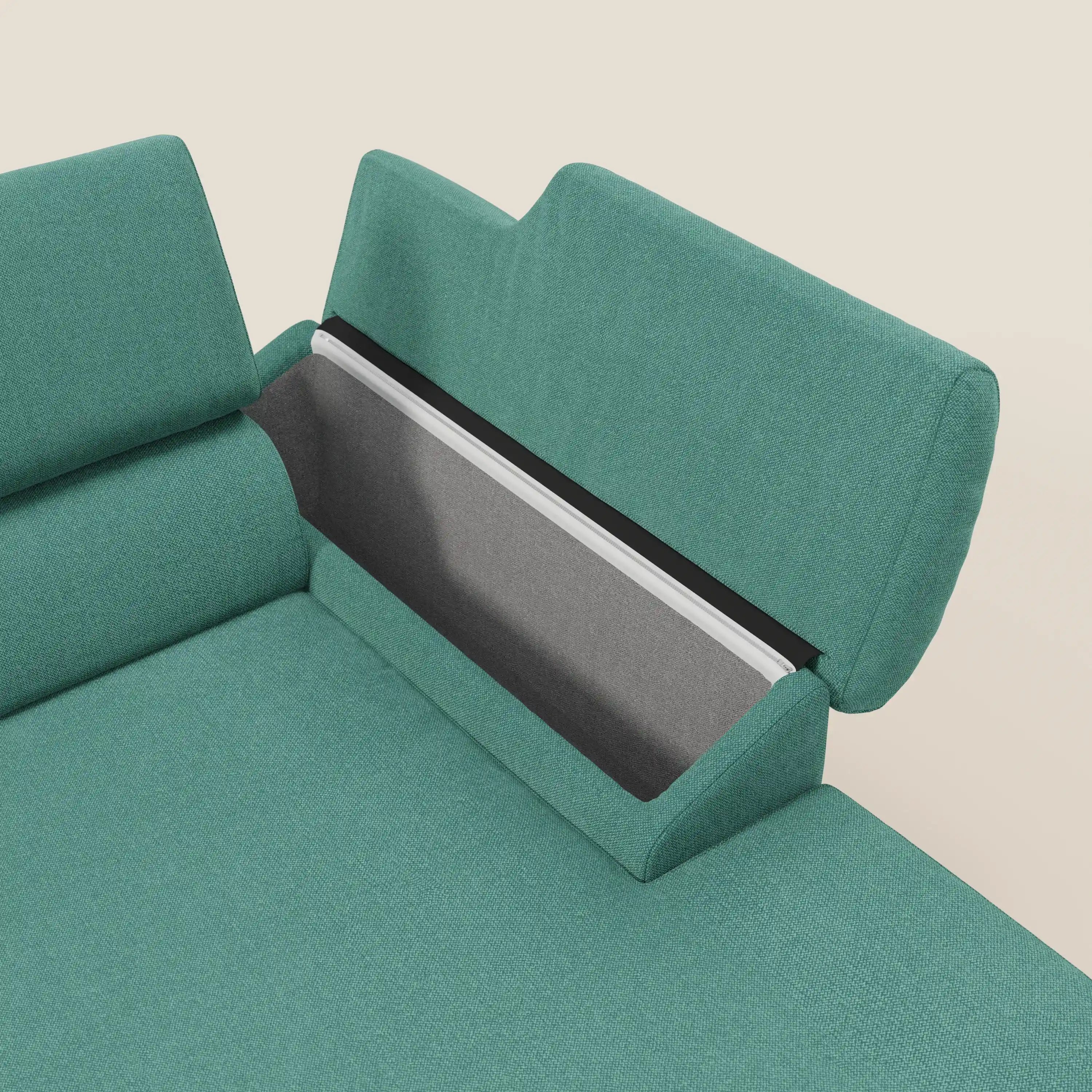 Il Donatello Divano angolare con sedute scorrevoli di Divani.Store, in tessuto T23 verde acqua, ha braccioli contenitore e poggiatesta. Lo schienale offre vano a giorno grigio per oggetti. Design contemporaneo su sfondo bianco sporco.