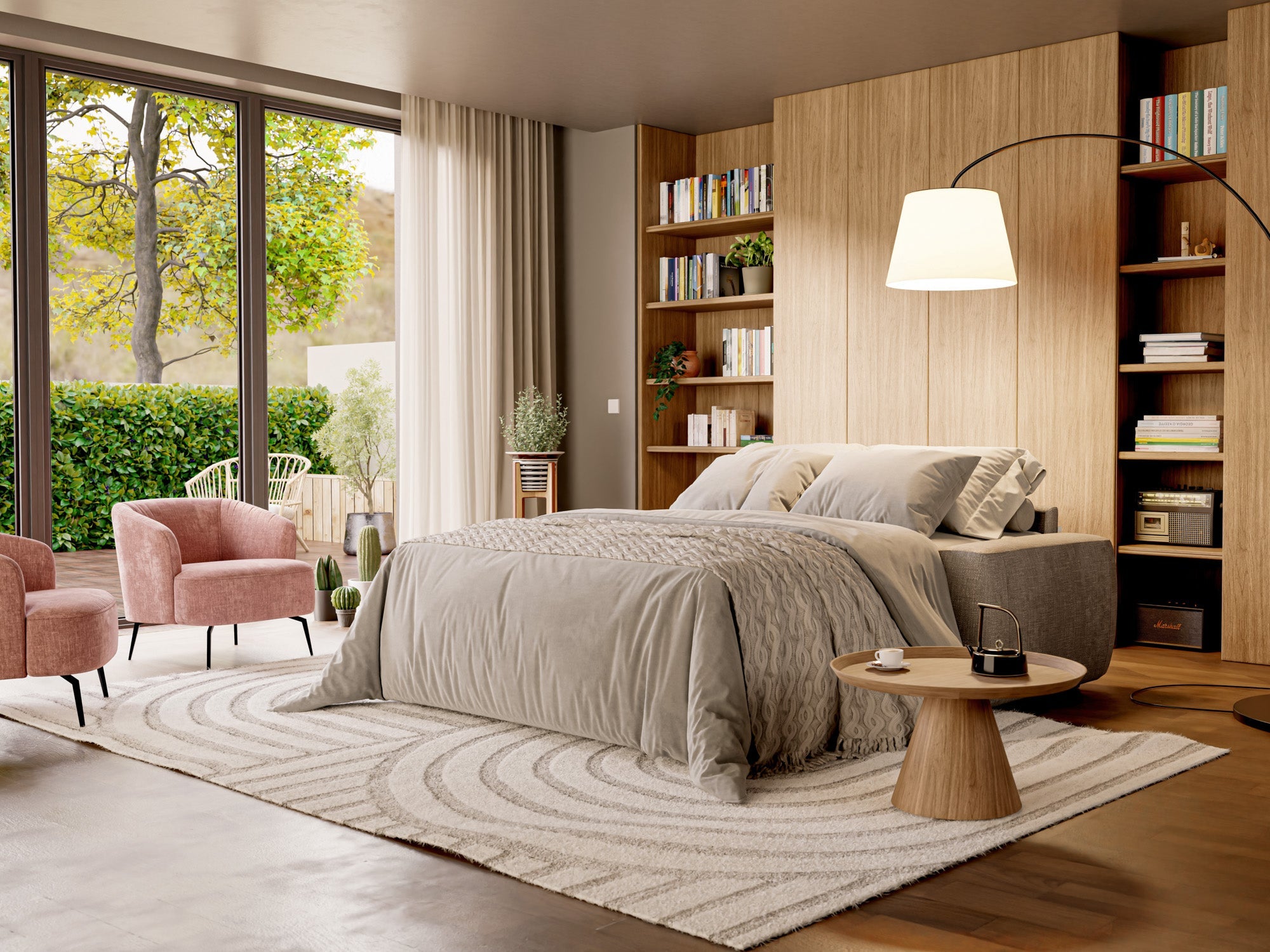 Camera da letto moderna con letto grande, biancheria da letto grigia, testata in legno, scaffali con libri, due sedie rosa, tavolo rotondo, lampada, tappeto e grande finestra che mostra il verde esterno.