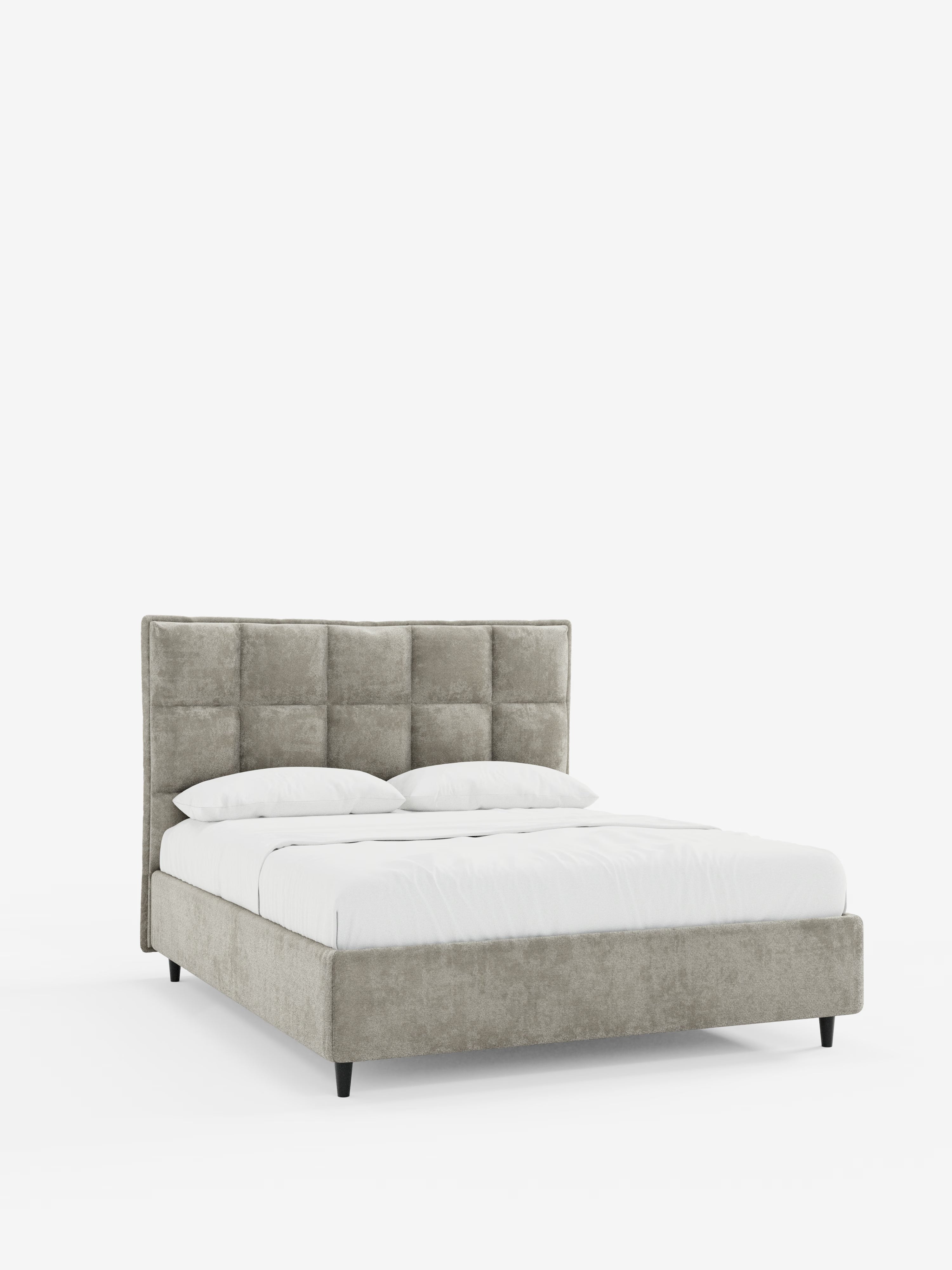 Un letto imbottito contemporaneo AURO con contenitore di Letti.store presenta una testiera alta e capitonné in ciniglia certificata Oeko-Tex® di colore grigio chiaro e una struttura in tinta. Il letto è rifinito con cura con biancheria da letto bianca e due cuscini, mentre le gambe affusolate nere completano il look. Su uno sfondo bianco a tinta unita, questo modello di Letti.store mette in risalto le linee moderne e slanciate e l’eleganza funzionale.