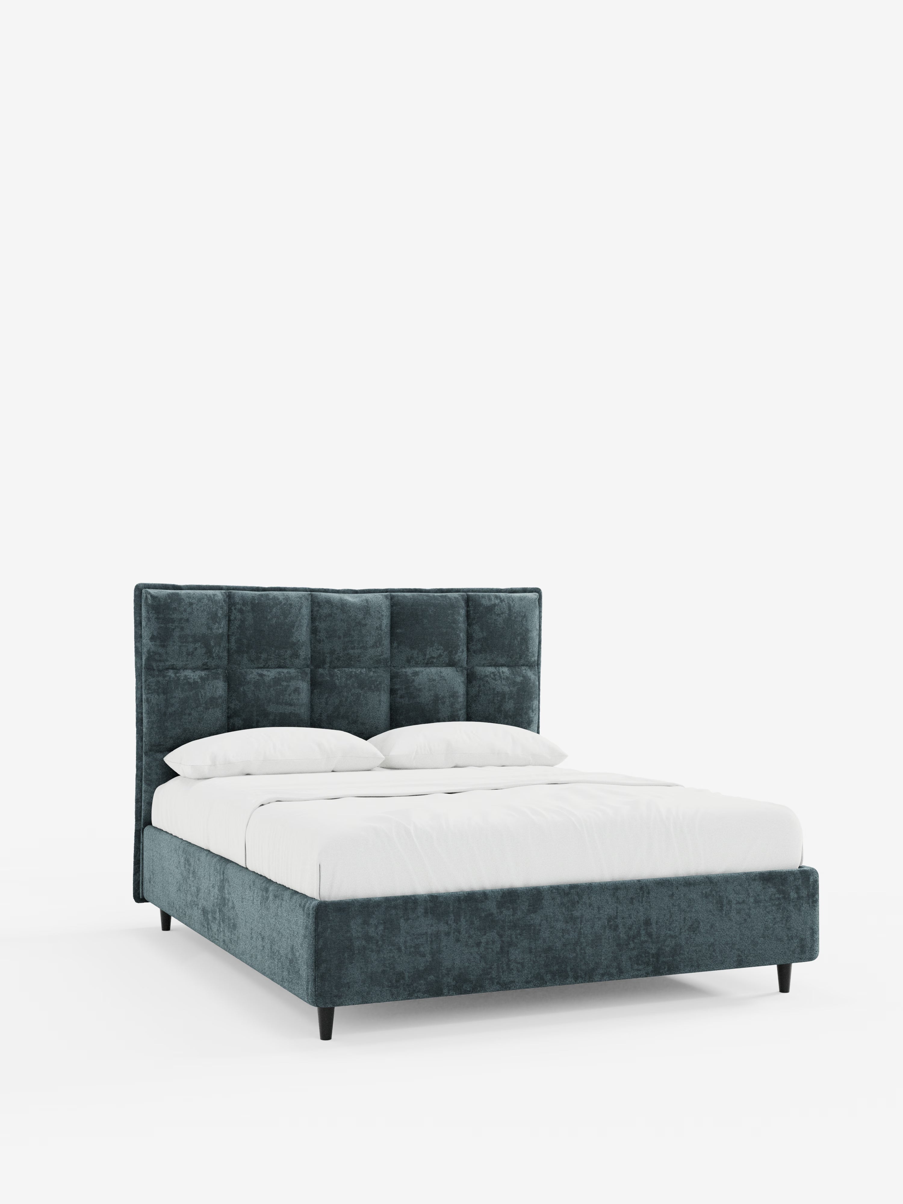 Scopri lo stile contemporaneo con il letto imbottito AURO di Letti.store, caratterizzato da una testiera altamente capitonata, splendidamente rivestita in ciniglia certificata Oeko-Tex®. Questo letto color verde acqua è dotato di un pratico vano contenitore ed è presentato ben rifatto con biancheria da letto candida e due cuscini coordinati, sostenuto da corte gambe nere su uno sfondo bianco a tinta unita.