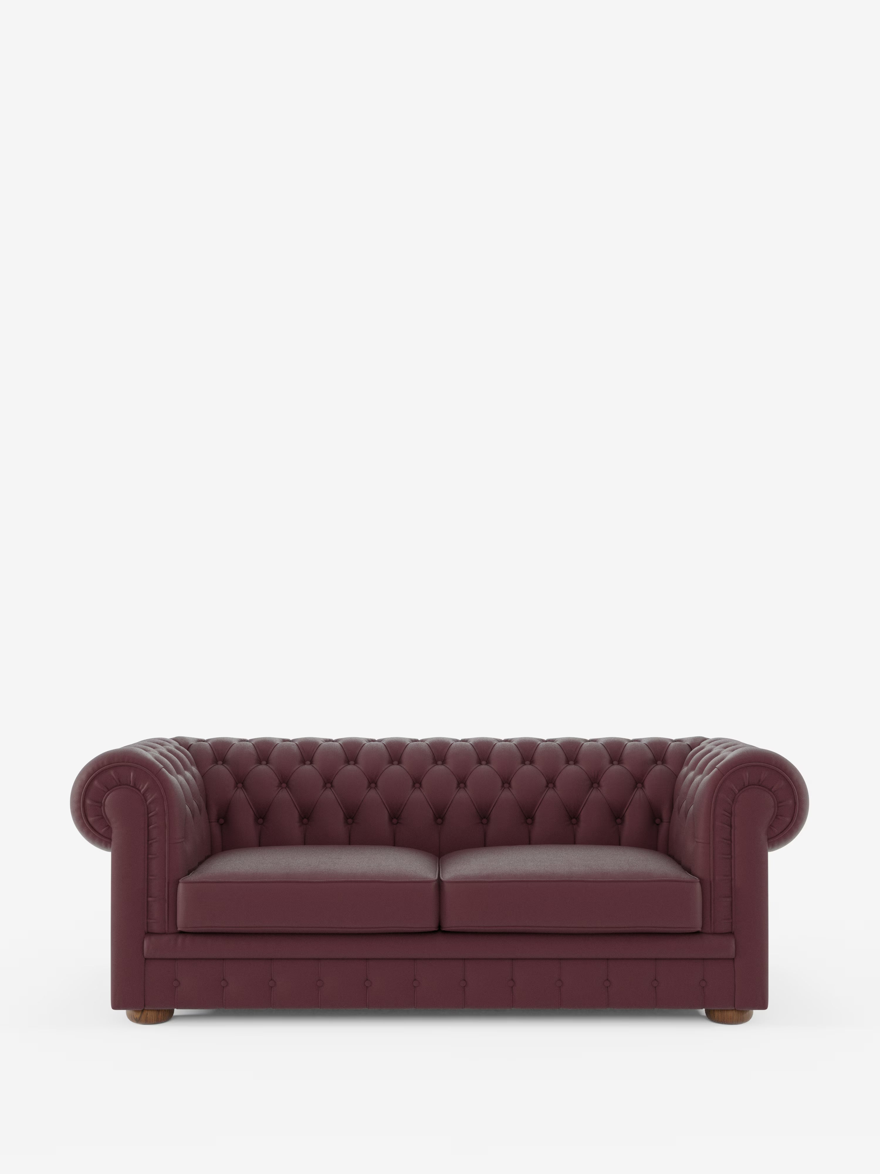 Un Chester color bordeaux – Divano Chesterfield in vera pelle spessorata a 2 e 3 posti di Divani.Store, caratterizzato da una profonda trapuntatura a bottoni sullo schienale e da braccioli arrotondati, è posizionato al centro su uno sfondo bianco a tinta unita. Questo divano italiano realizzato a mano è dotato di due cuscini di seduta e piedini in legno.