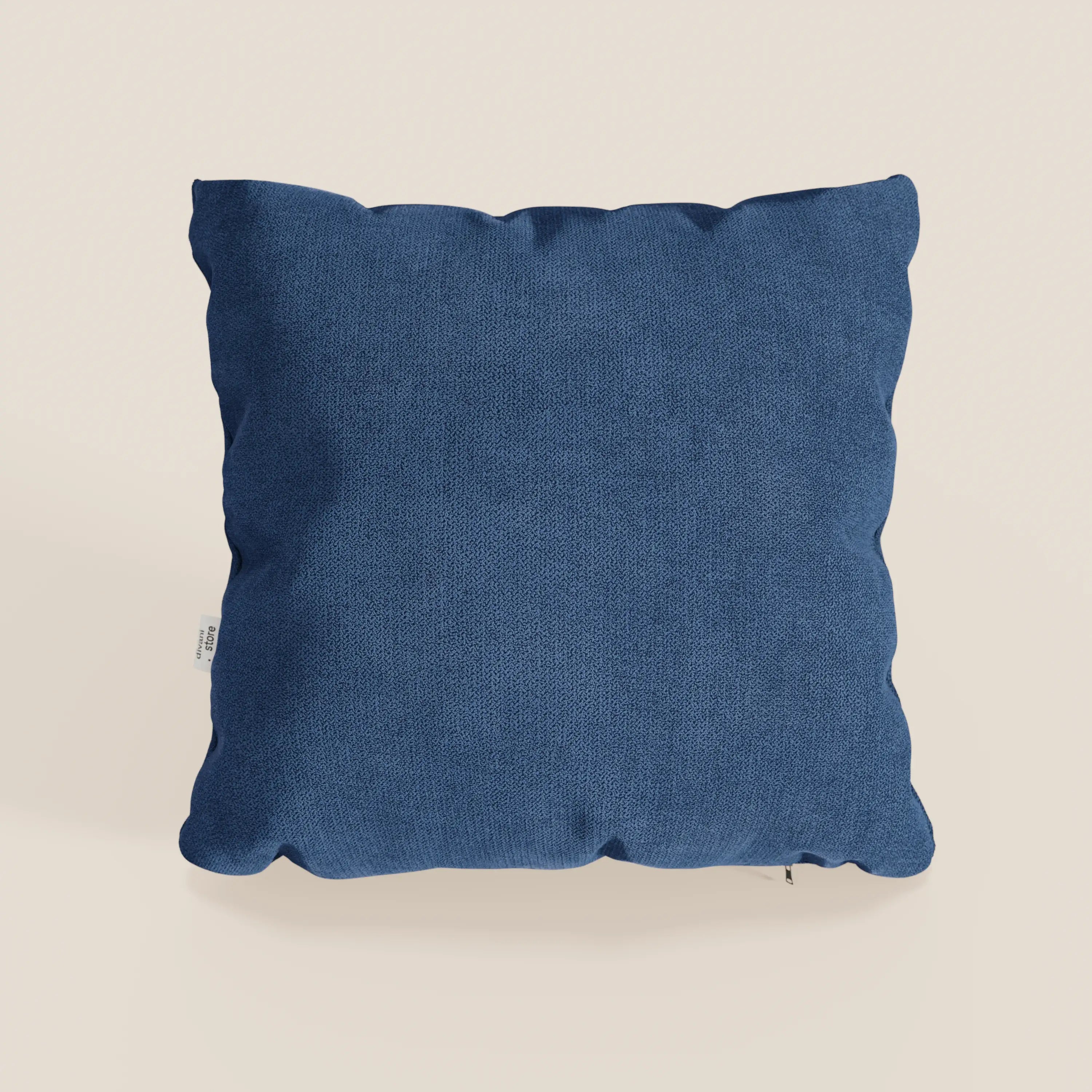 Il cuscino Destiny di Divani.Store, 45x45 cm in morbido tessuto impermeabile blu T02, ha una forma quadrata, una superficie strutturata e una targhetta bianca sul bordo sinistro. Su uno sfondo neutro con ombre che ne evidenziano la morbidezza.