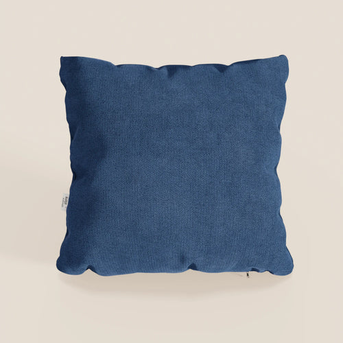 Il cuscino Destiny di Divani.Store, 45x45 cm in morbido tessuto impermeabile blu T02, ha una forma quadrata, una superficie strutturata e una targhetta bianca sul bordo sinistro. Su uno sfondo neutro con ombre che ne evidenziano la morbidezza.