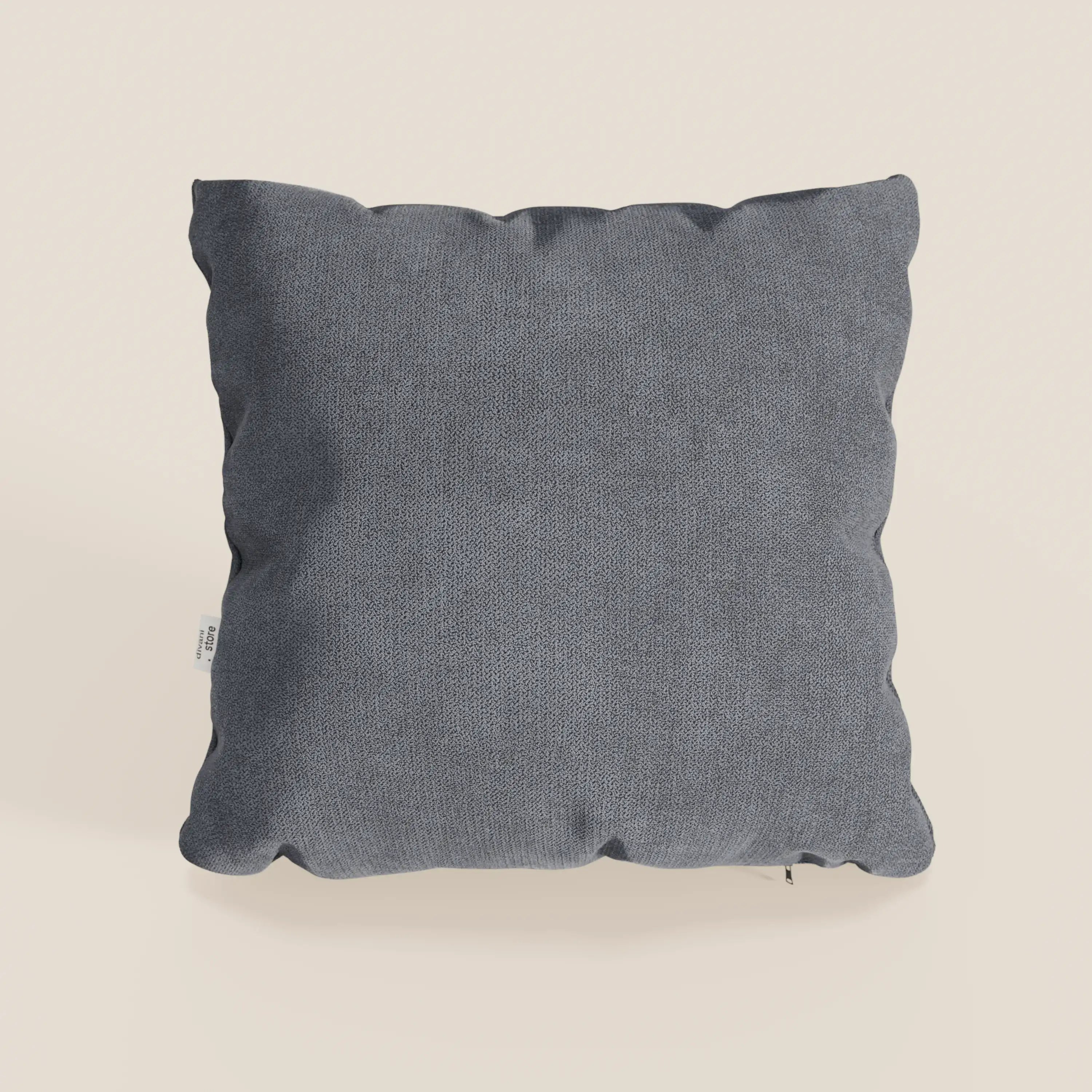 Il cuscino Destiny di Divani.Store, nel colore T02 grigio, è un cuscino quadrato in tessuto impermeabile di colore grigio medio, con una texture sottile e un aspetto morbido e soffice. Una piccola etichetta di manutenzione bianca è visibile sulla cucitura sinistra su uno sfondo beige chiaro.
