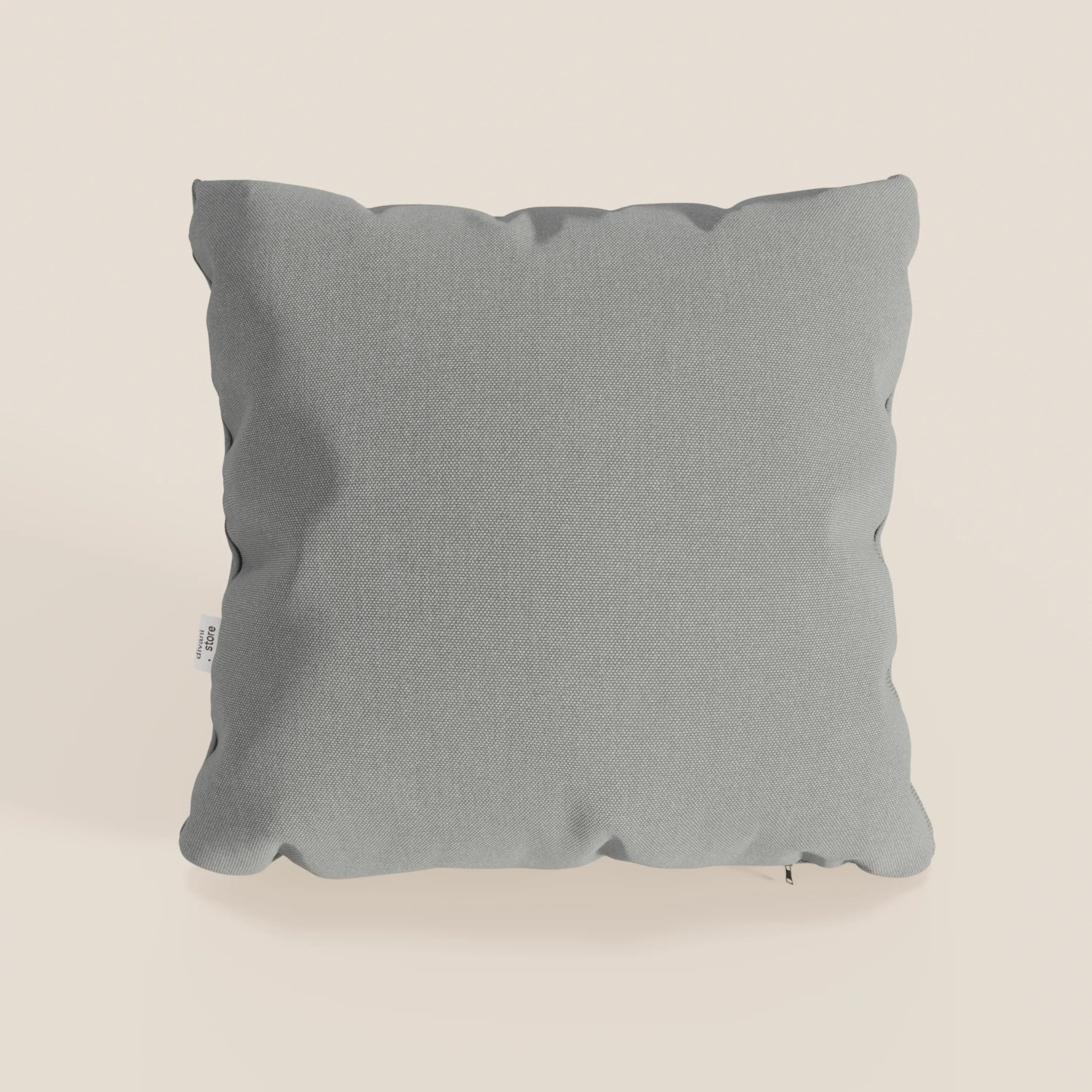 Il cuscino Divani.Store Honey in T13 grigio, 45x45 cm, ha una forma quadrata con angoli arrotondati, cuciture sottili sui bordi, una piccola etichetta bianca sul lato sinistro ed è realizzato in tessuto impermeabile tipo cotone.