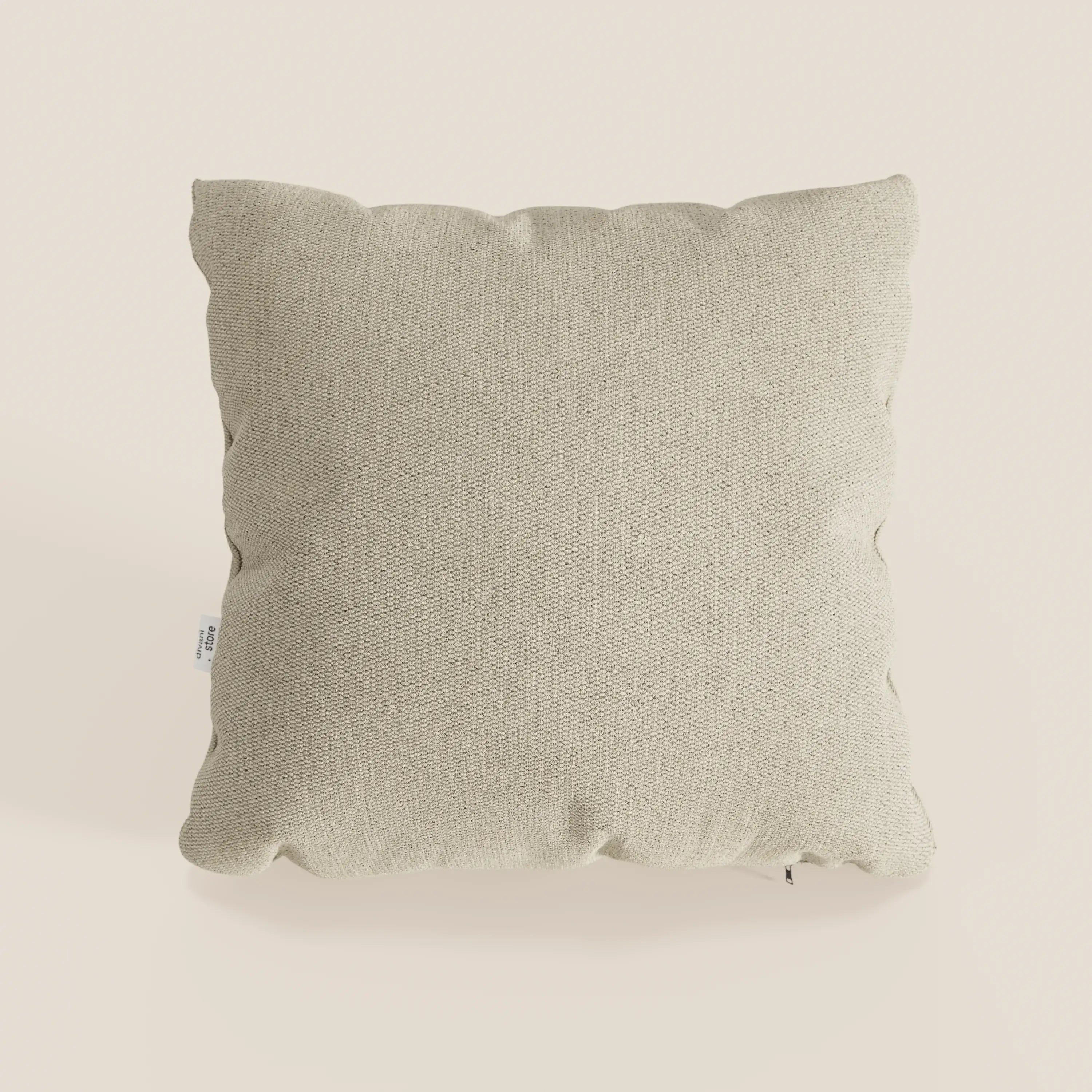 Il cuscino Miami di Divani.Store, 45x45 cm in T14 beige, è caratterizzato da un morbido tessuto impermeabile, angoli delicatamente arrotondati e una discreta etichetta laterale bianca. Il cuscino, dal design semplice, è posizionato su uno sfondo color crema chiaro.