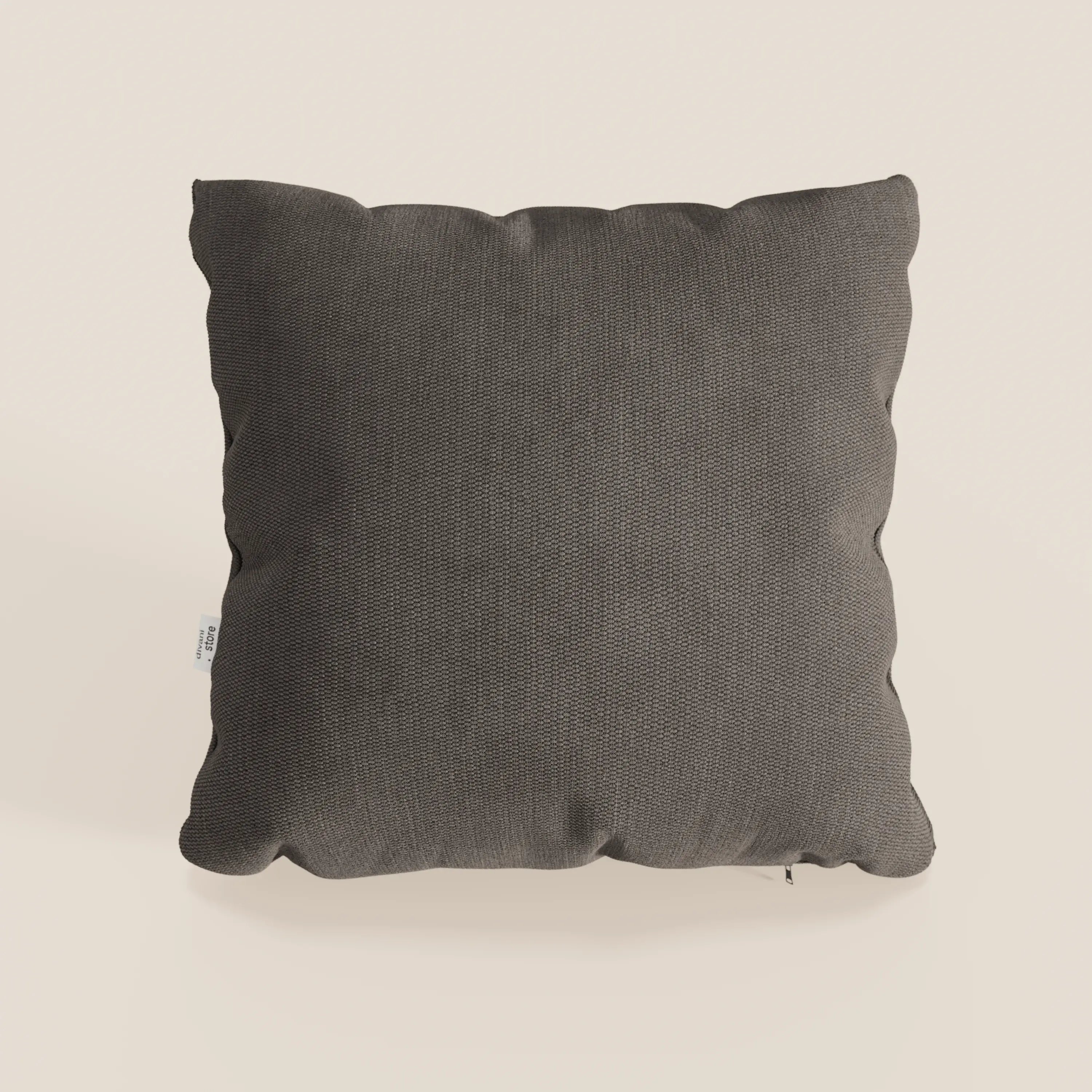 Il cuscino Miami di Divani.Store, nel formato 45x45 cm T14 marrone, è caratterizzato da un tessuto morbido impermeabile, una texture sottile, angoli arrotondati e una targhetta bianca per un look semplice e moderno su uno sfondo beige chiaro.