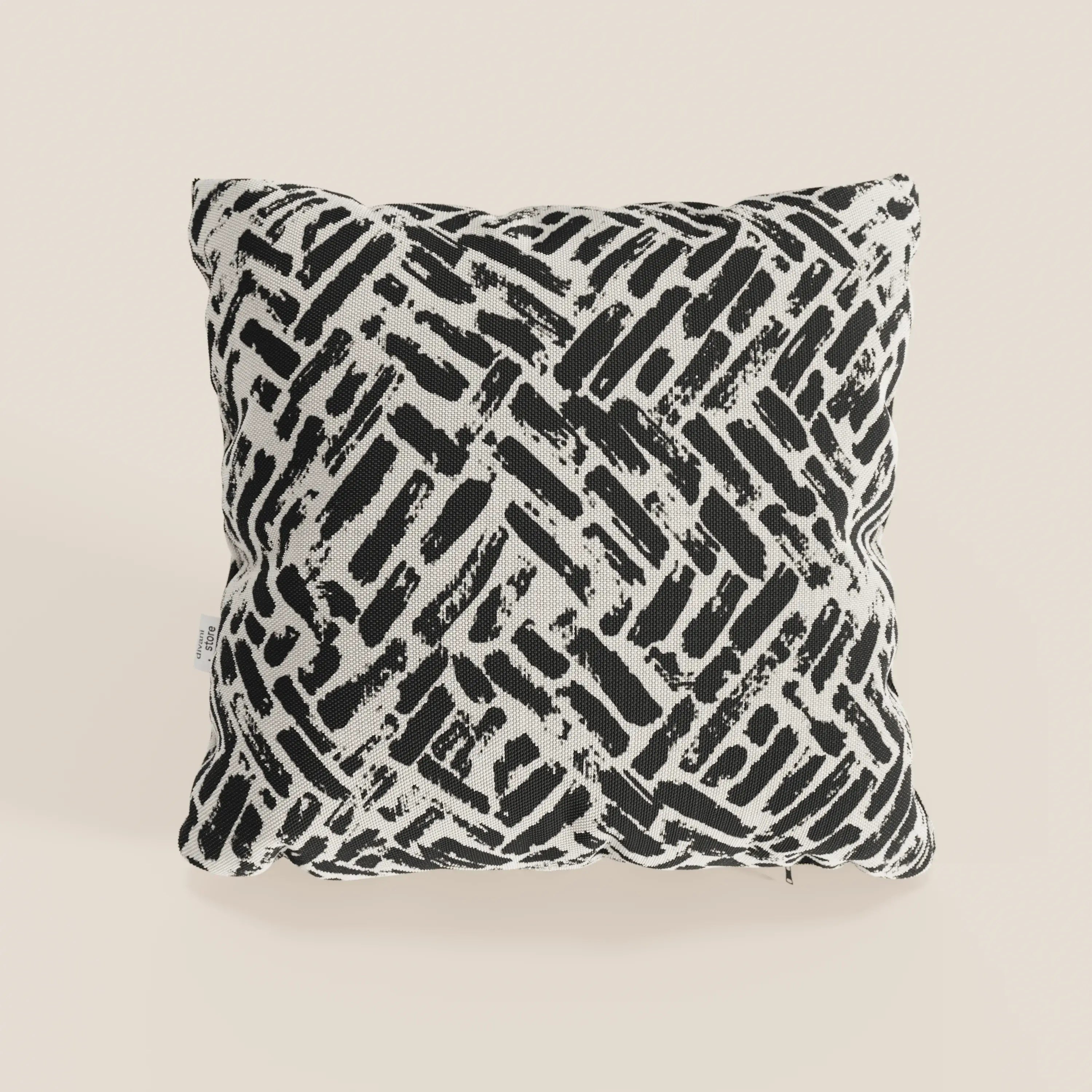 Il cuscino geometrico Brick di Divani.Store, in tessuto nero idrorepellente e disponibile in vari colori, dona un tocco dinamico a qualsiasi spazio, appoggiandosi elegantemente sulle superfici chiare.