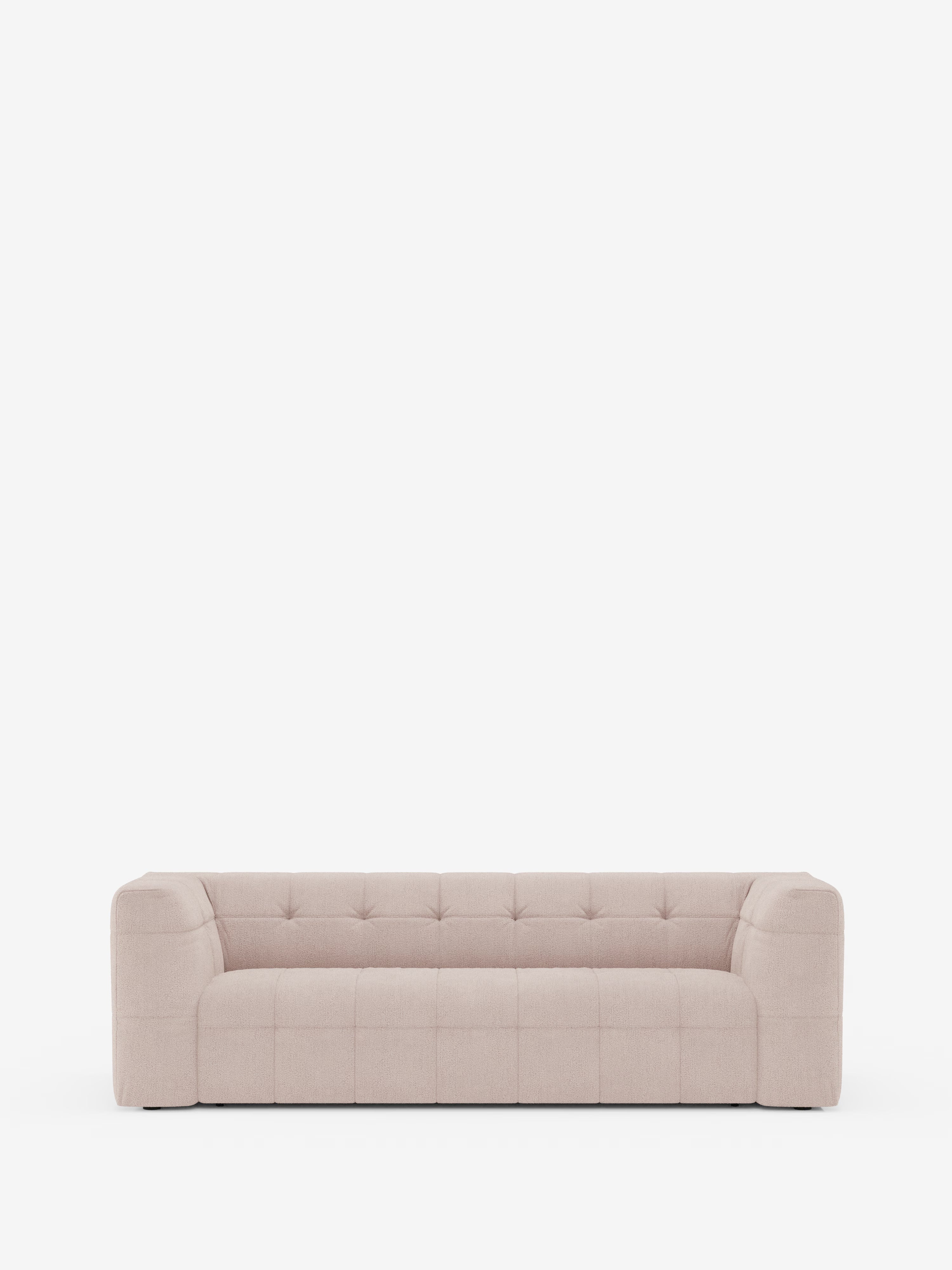 Un moderno divano modulare Mosaic a 3 e 4 posti in bouclé di Divani.Store, realizzato in tessuto T21 beige chiaro antimacchia e caratterizzato da un motivo a griglia capitonné, con braccioli squadrati e schienale basso, si stacca su uno sfondo bianco a tinta unita. Questo divano modulare minimalista è privo di cuscini o decorazioni.